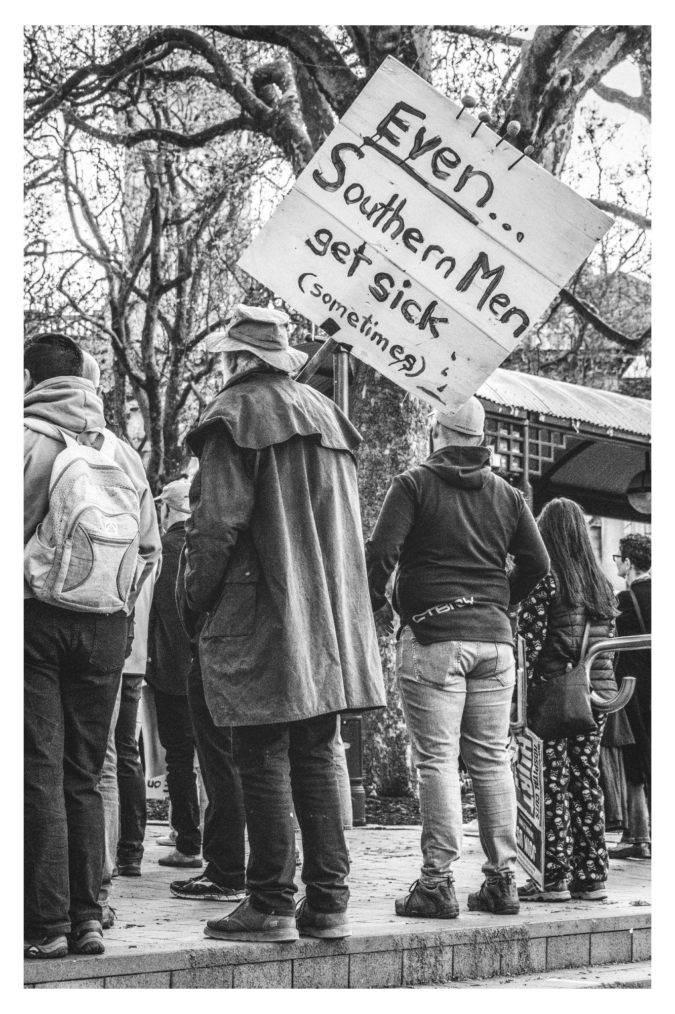 An old timer with a sign reading 'Even Souther Men get sick (sometimes)'