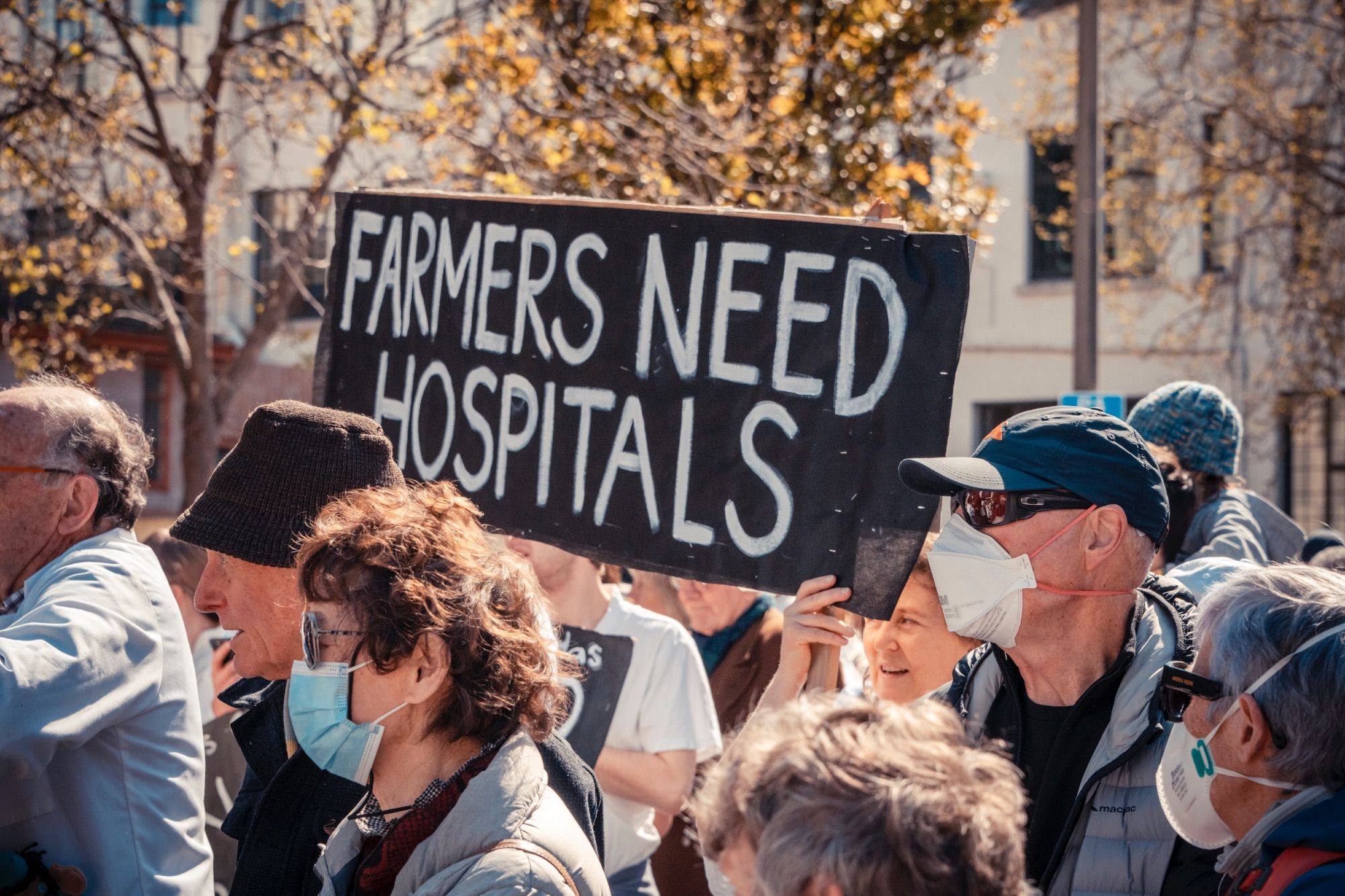 Amongst the protests this sign says 'Farmers Need Hospitals'