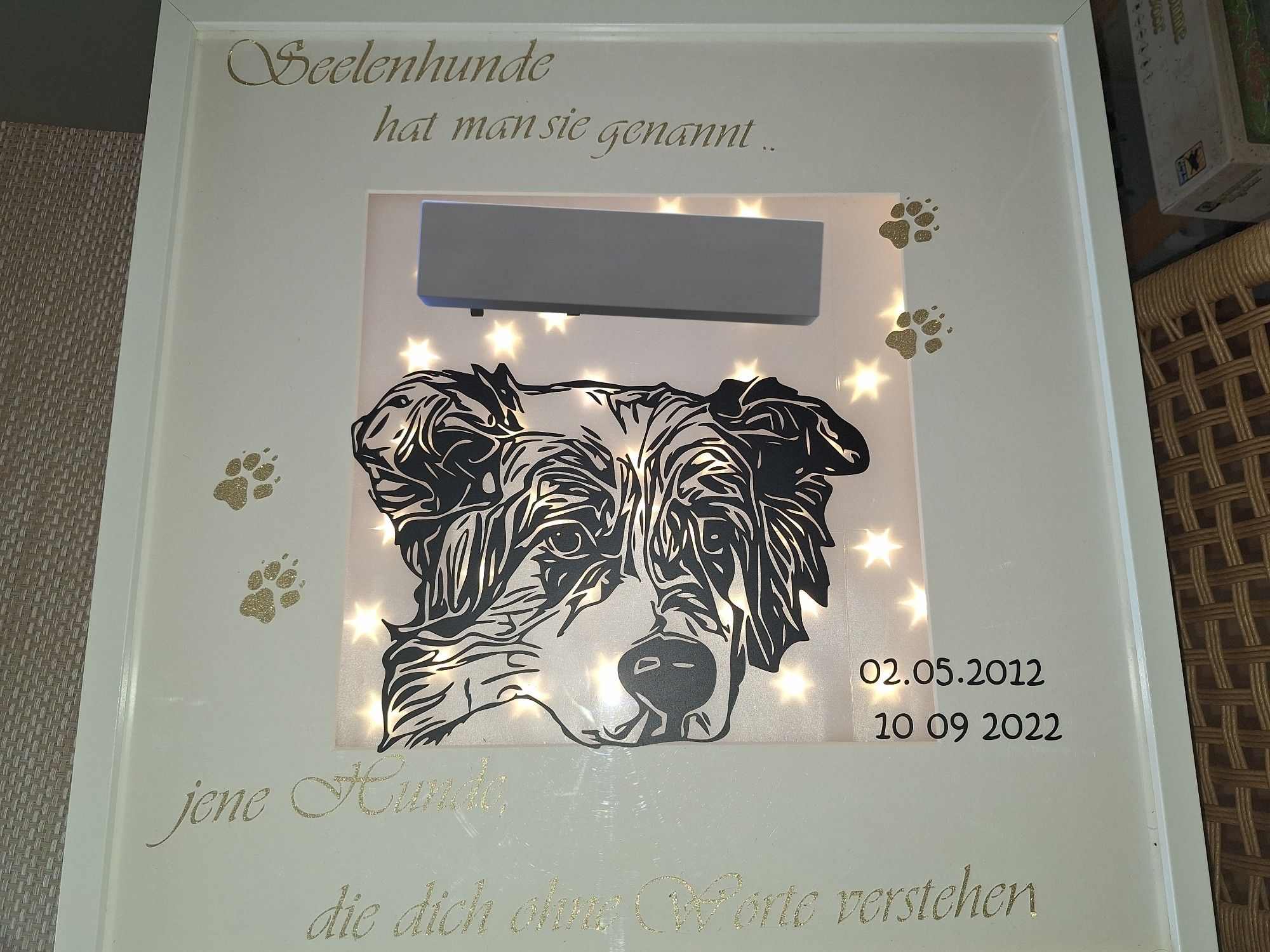 Bilderrahmen beleuchtet mit aufgeklebt Hundekopf, Sterneffekt Hintergrund und einem Spruch (Seelenhunde hat man sie genannt, jene Hunde, die dich ohne Worte verstehen). Der Name des Hundes ist mit einem schwarzen Balken abgedeckt