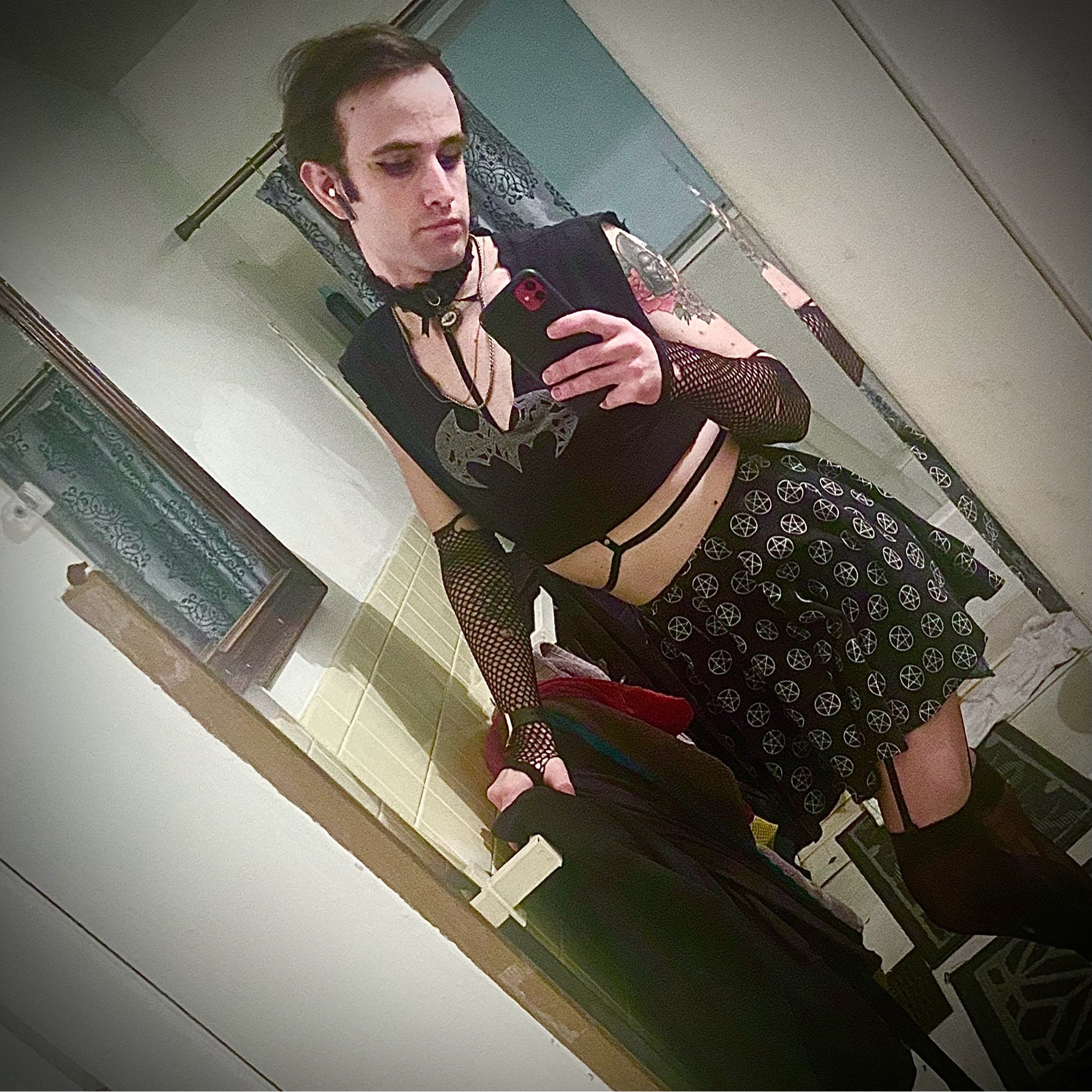 Bathroom selfie in choker necklace, pentagram skirt, harness, leggings and garter belt