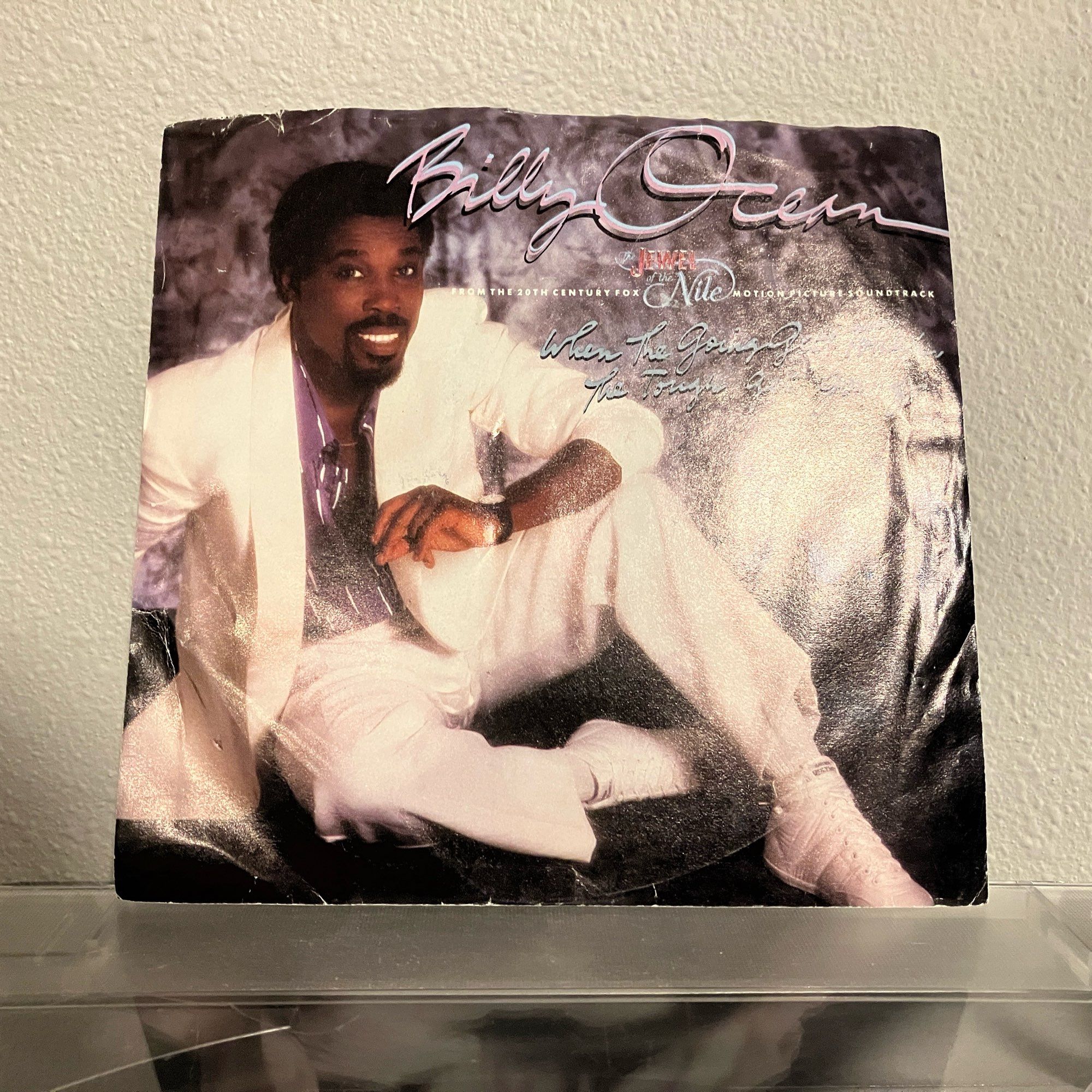 7" record sleeve with a photo of a black man in a very white suit, labelled using at least four typefaces as Billy Ocean; From the 20th Century Fox "The Jewel of the Nile" Motion Picture Soundtrack; When The Going Gets Tough, The Tough Get Going