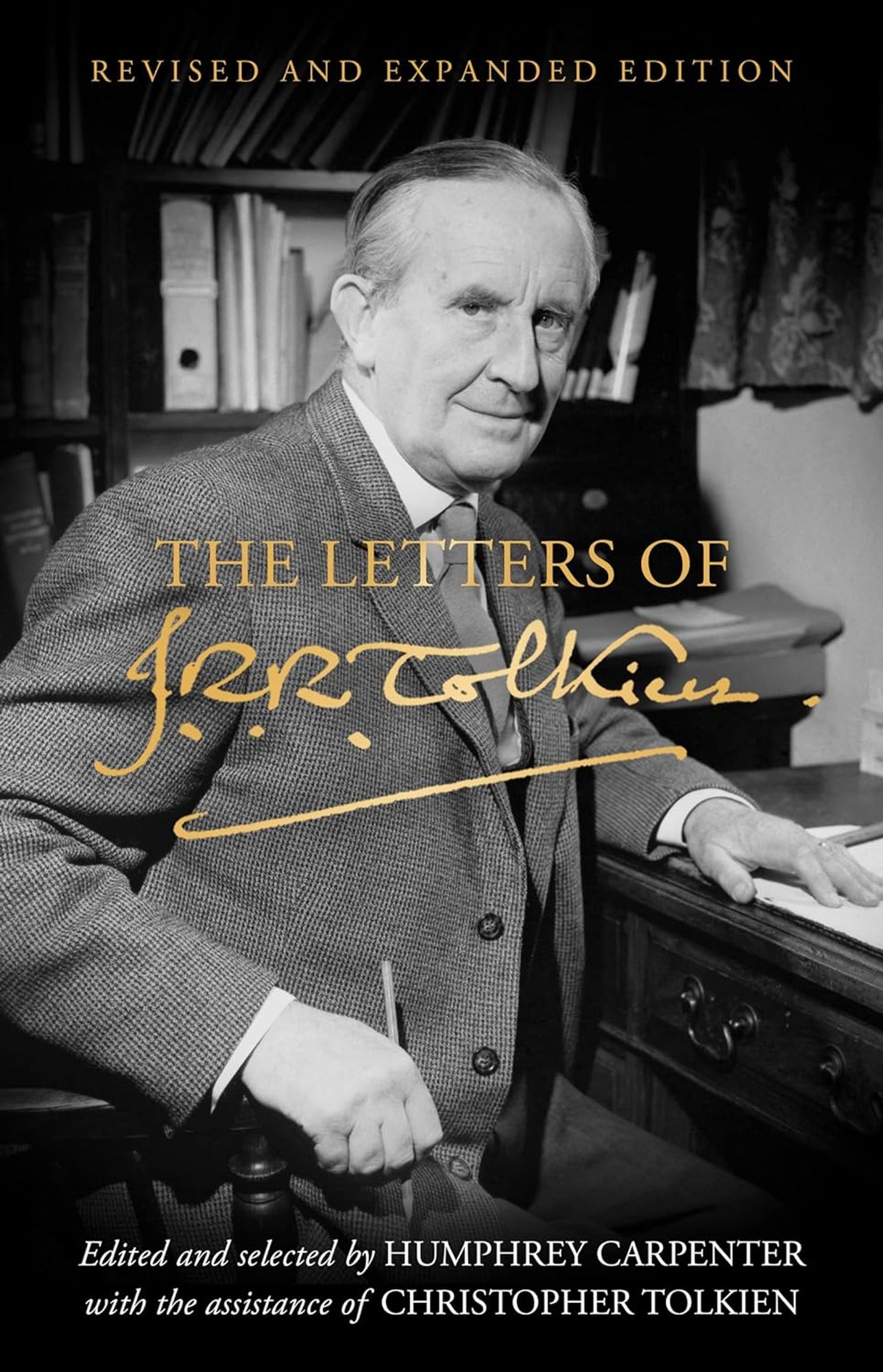 Cover of the new “The Letters of J. R. R. Tolkien” showing JRR Tolkien looking at the camera and holding a pencil in one hand, the other placed on a table.