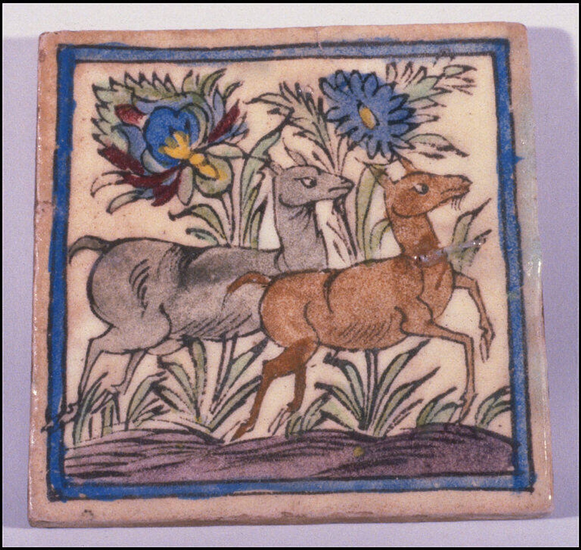 official museum photo of object: painted square tile, decorated with image of two deer (one grey, one brown) running together under two gigantic blue flowers, framed with blue border