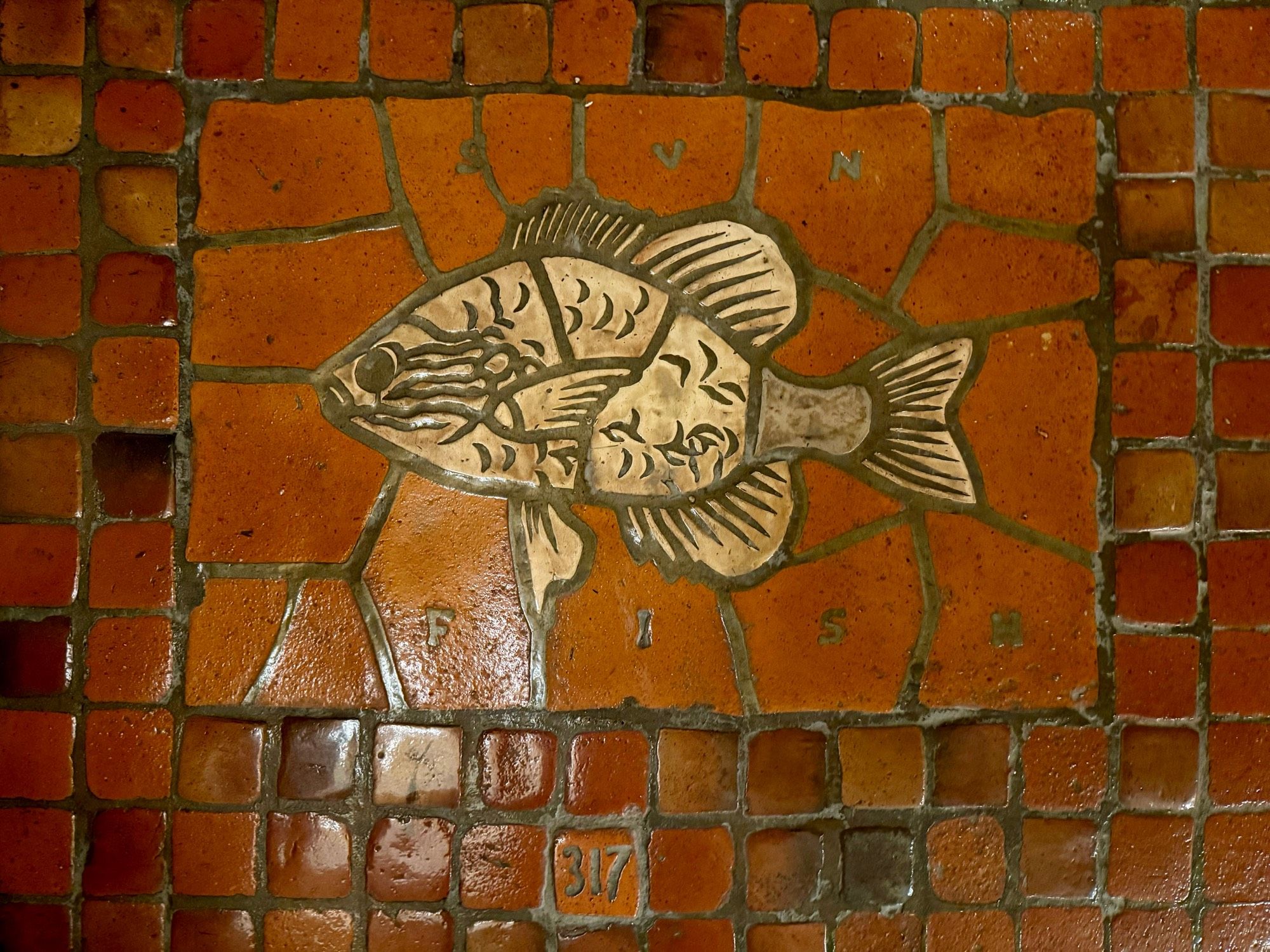 photo of the sunfish floor tile mosaic, labeled “SUN FISH” and numbered “317”