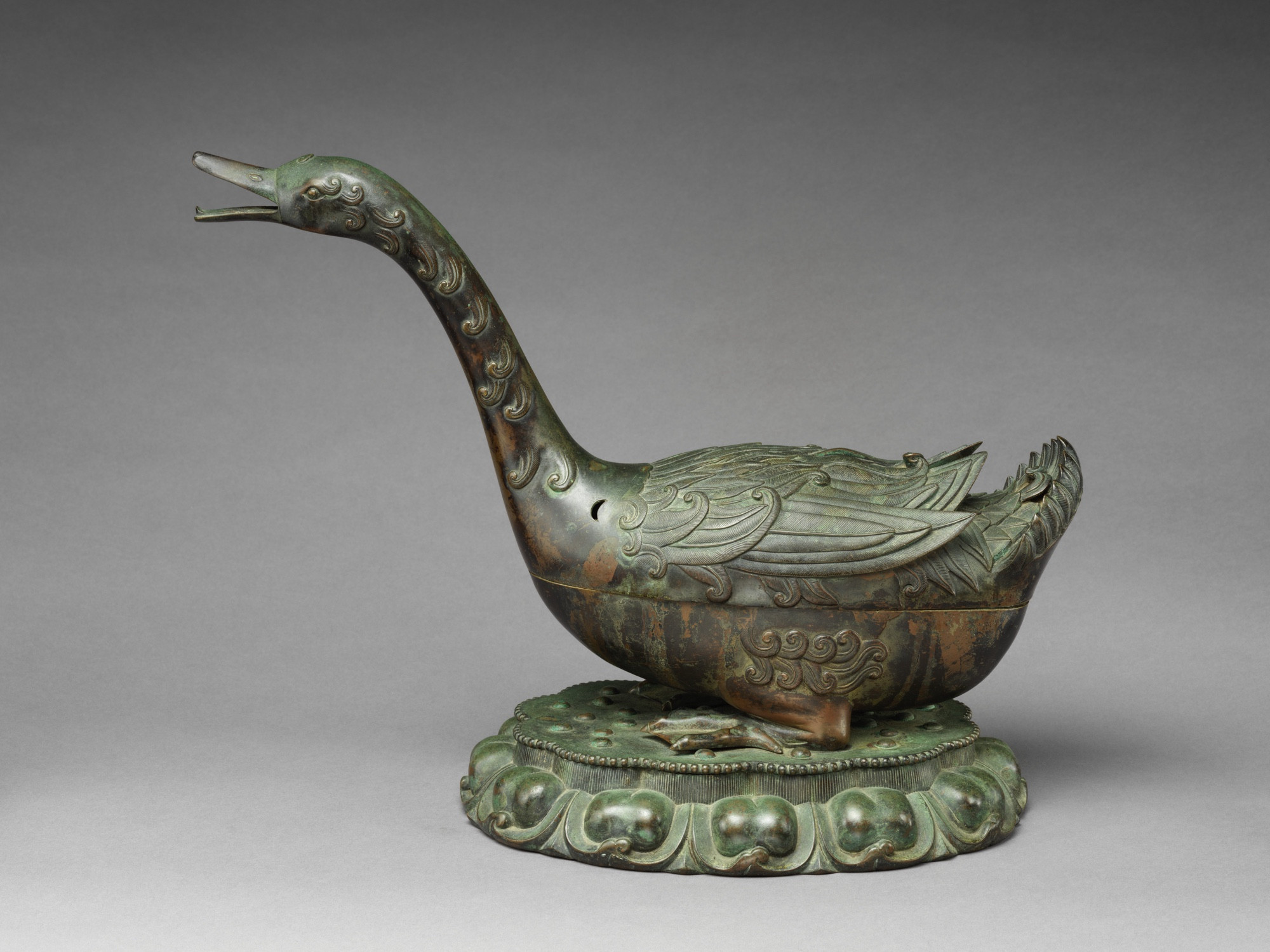 official museum photo of the object on grey background, side profile 2: incense burner in the form of a sitting goose with neck outstretched, bronze with green patina