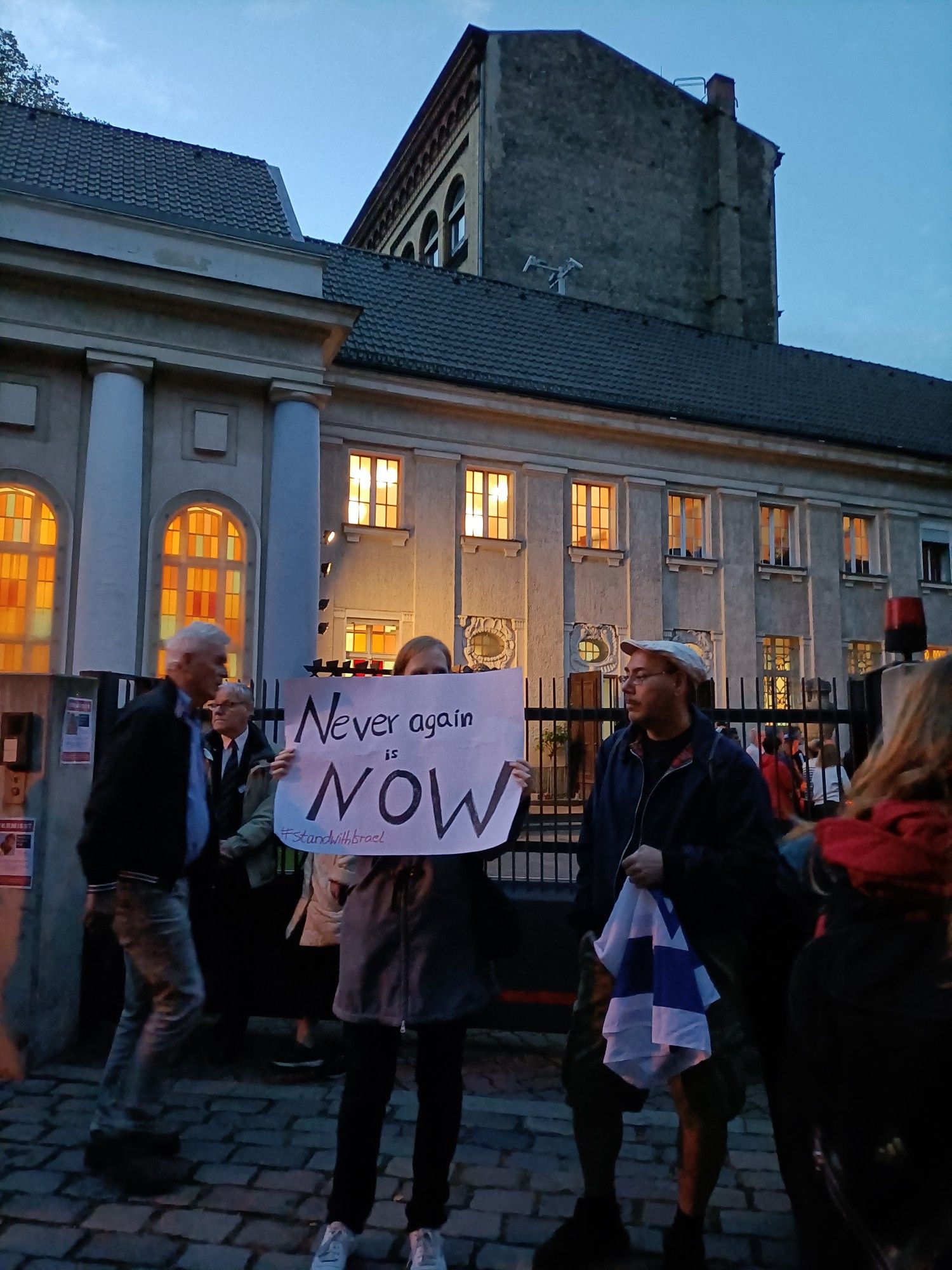 Menschen vor der Jüdischen Synagoge am Fraenkleufer in Berlin-Kreuzberg, auf dem Schild steht: "Never again ist now"