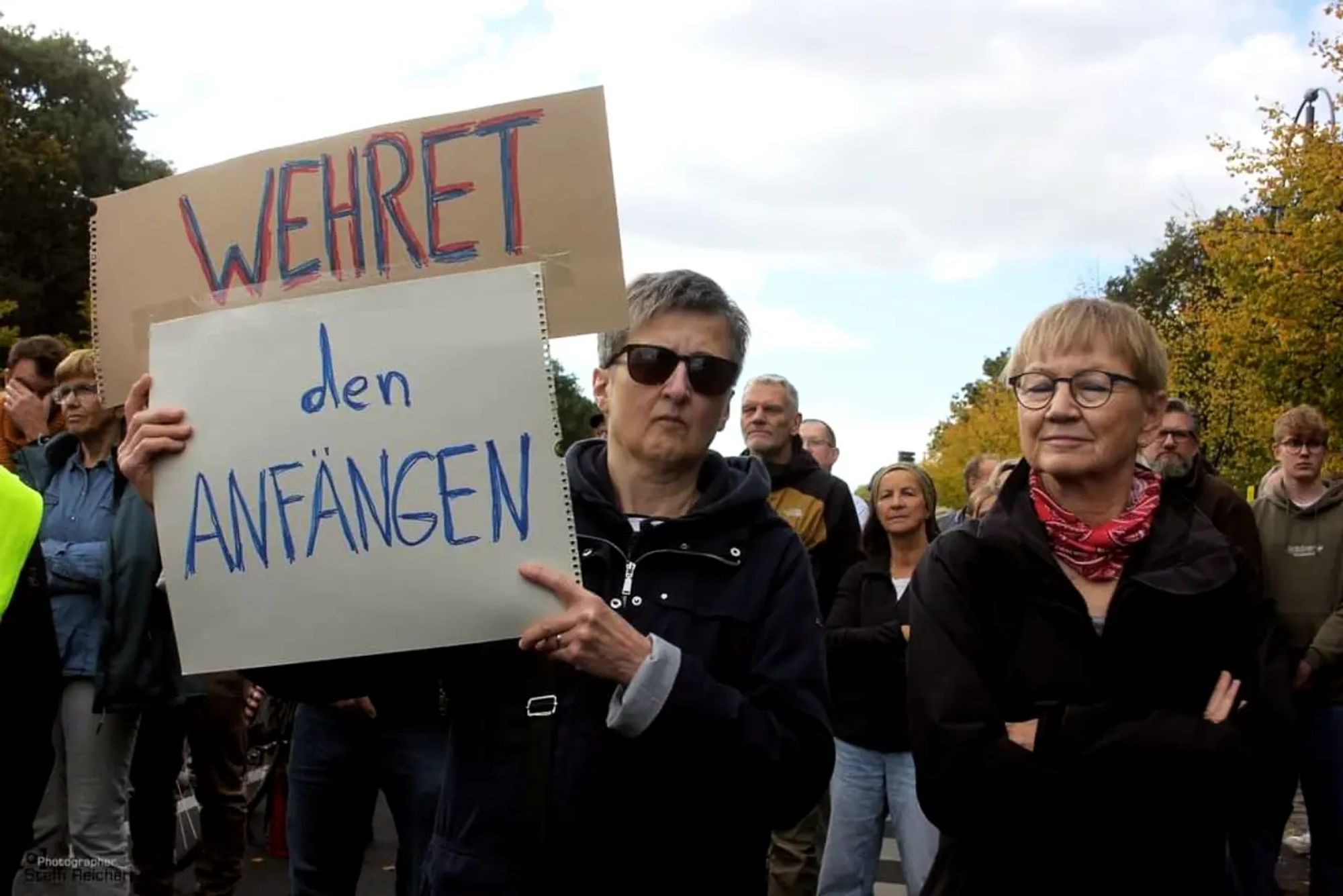 Menschen mit Plakat, auf dem steht: " Wehret den Anfängen".