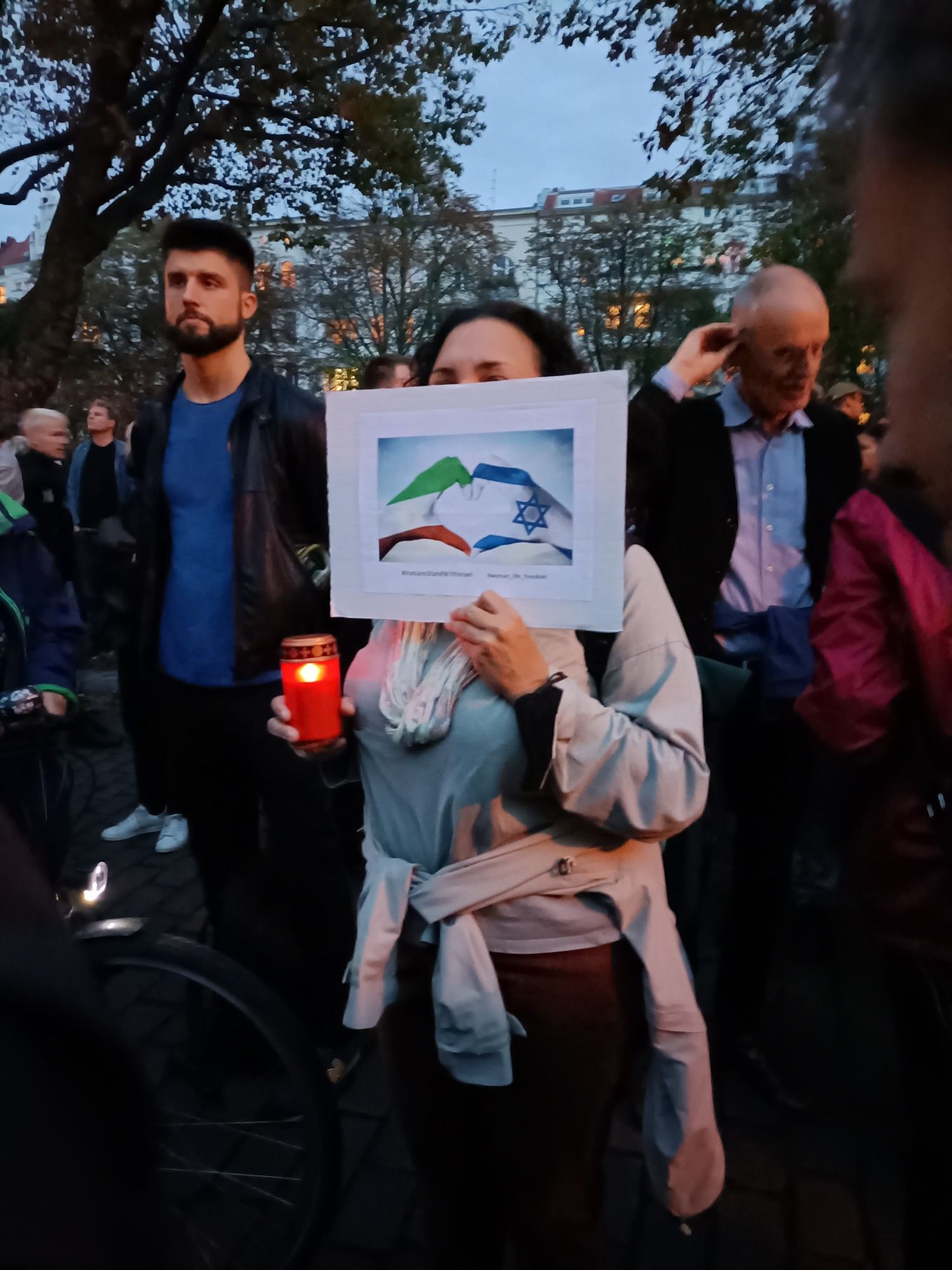 Menschen vor der Jüdischen Synagoge am Fraenkleufer in Berlin-Kreuzberg, auf dem Schild steht: "IraniensStandwithIsrael" "WomenlifeFreedom"