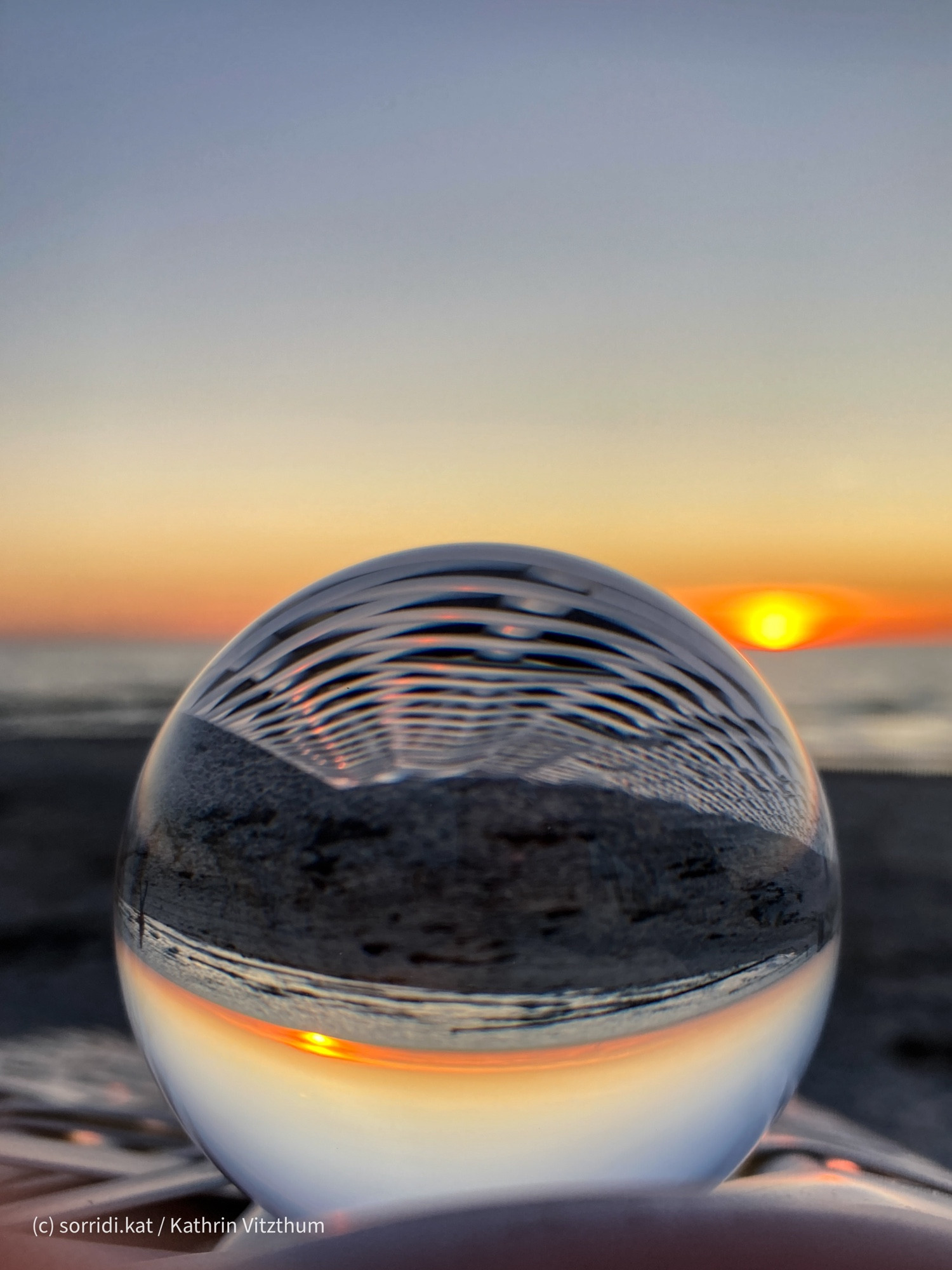 Lensball auf Strandkorb vor Sonnenuntergang.