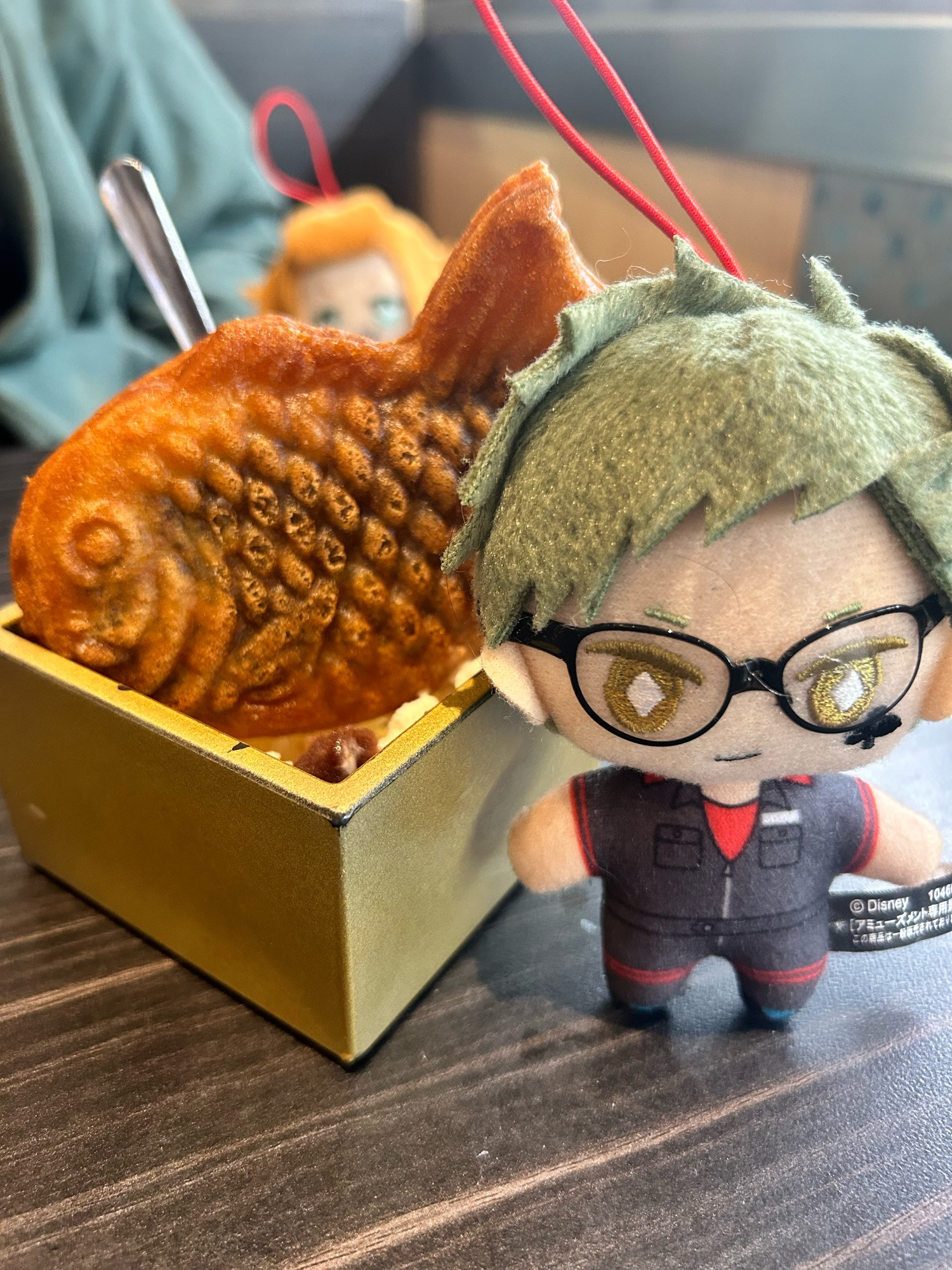 Trey clover nui, posed next to a taiyaki dessert. Cater diamond nui can be seen in the background 