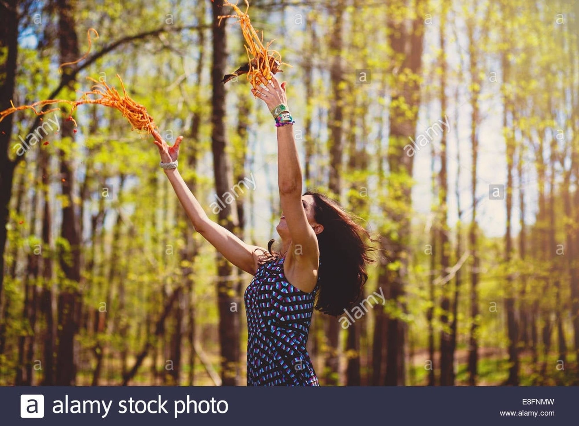 A woman joyously throwing spaghetti in a sunny forest. Why does this image exist? Who can say. Alamy stock.