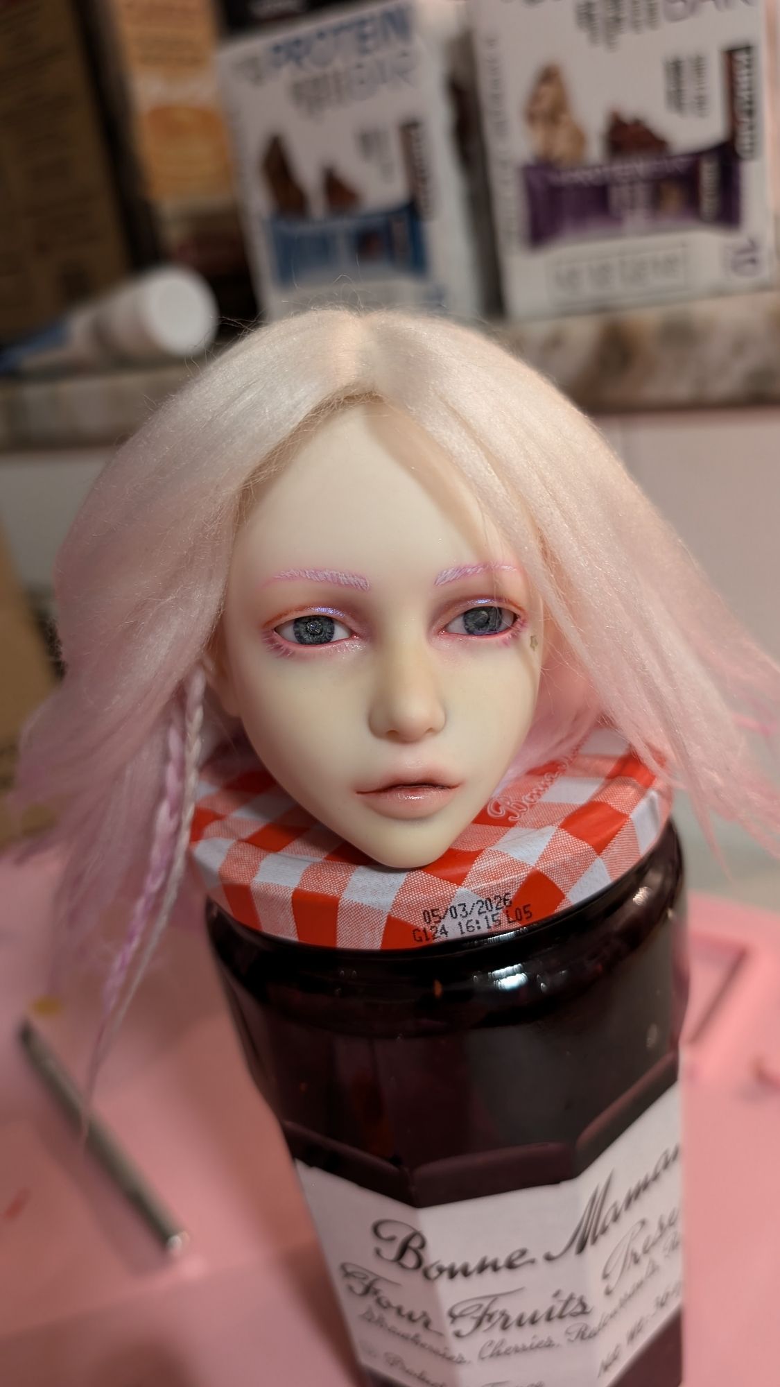 Completed faceup for a ball jointed doll. The colors are primarily purple tinted. She's wearing holo-reflective makeup and has a star on one cheek near her eye. She is wearing a white and purple yarn weft wig with braids. 