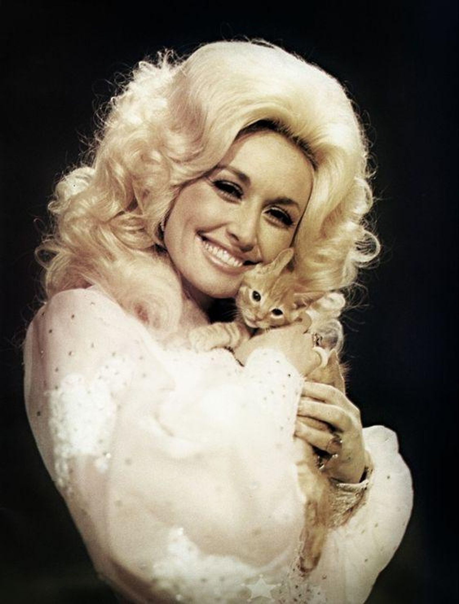 Image is Dolly Parton with a young cat