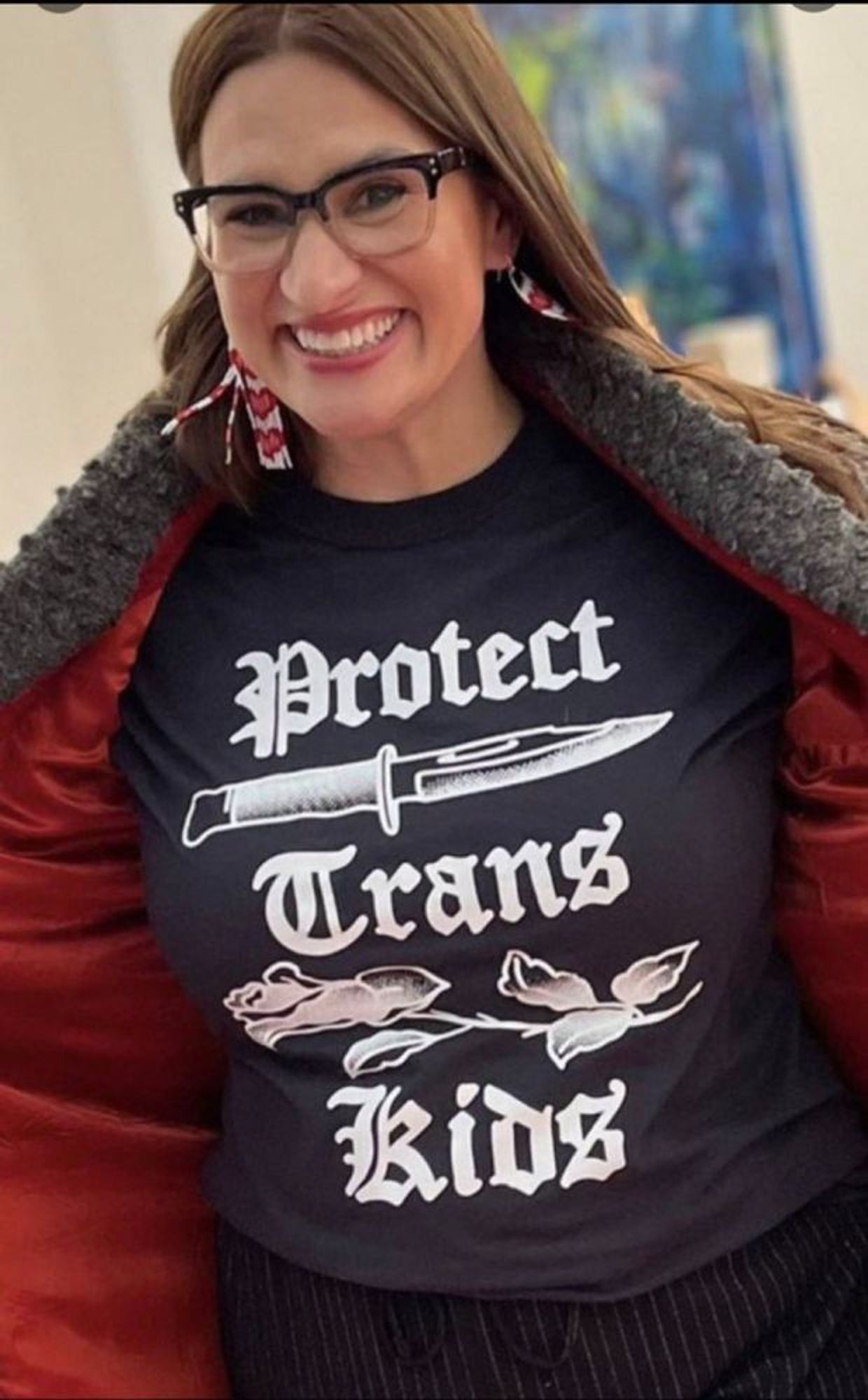 Image shows Peggy Flanagan wearing a 'protect trans kids' tshirt