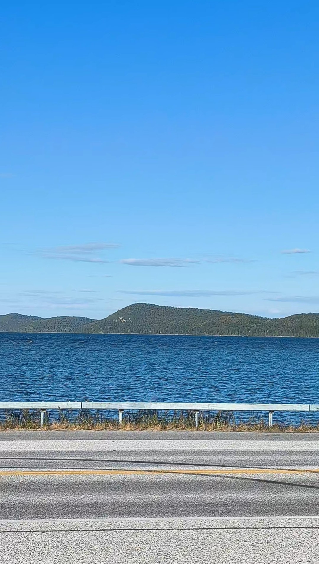 The other side of the causeway ! Across a small two lane road, the blue lake stretches out until blocked in by a cordon of greentop mountains