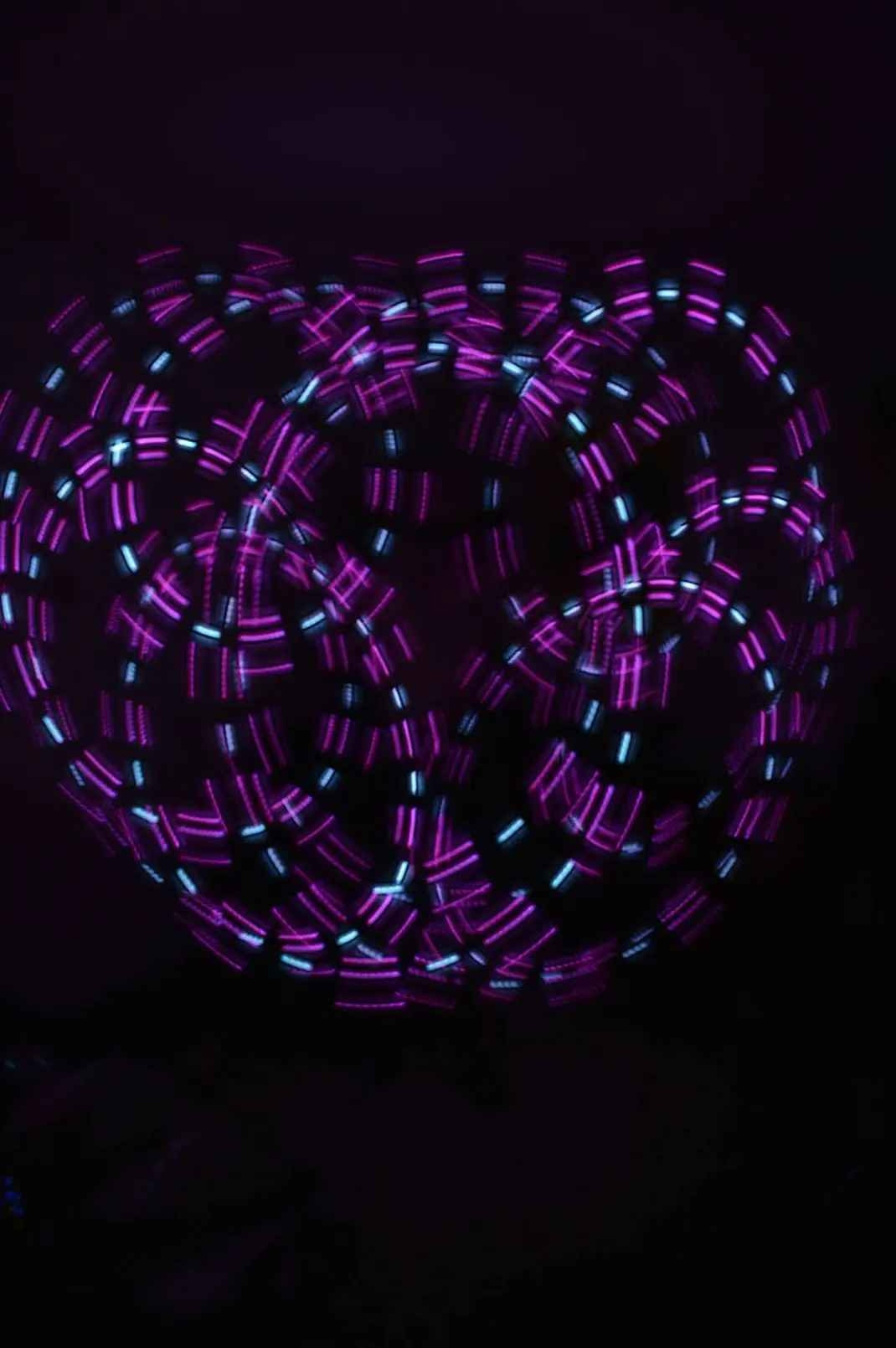 A kaleidoscopic light painting in purple and white hashed circles forming several overlapping circles linked in radial symmetry 