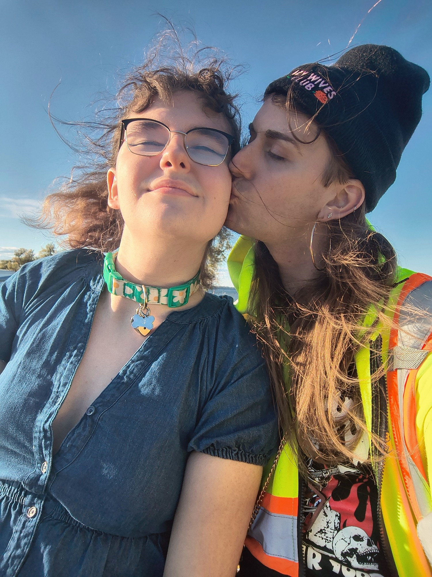 (Another shot of Colie kissing Rayna on the cheek) Behind Rayna's sunlit hair blowing in the breeze is a small glimpse of water and trees peeking out, their distant branches separating the horizon line of water from the expansive sky.