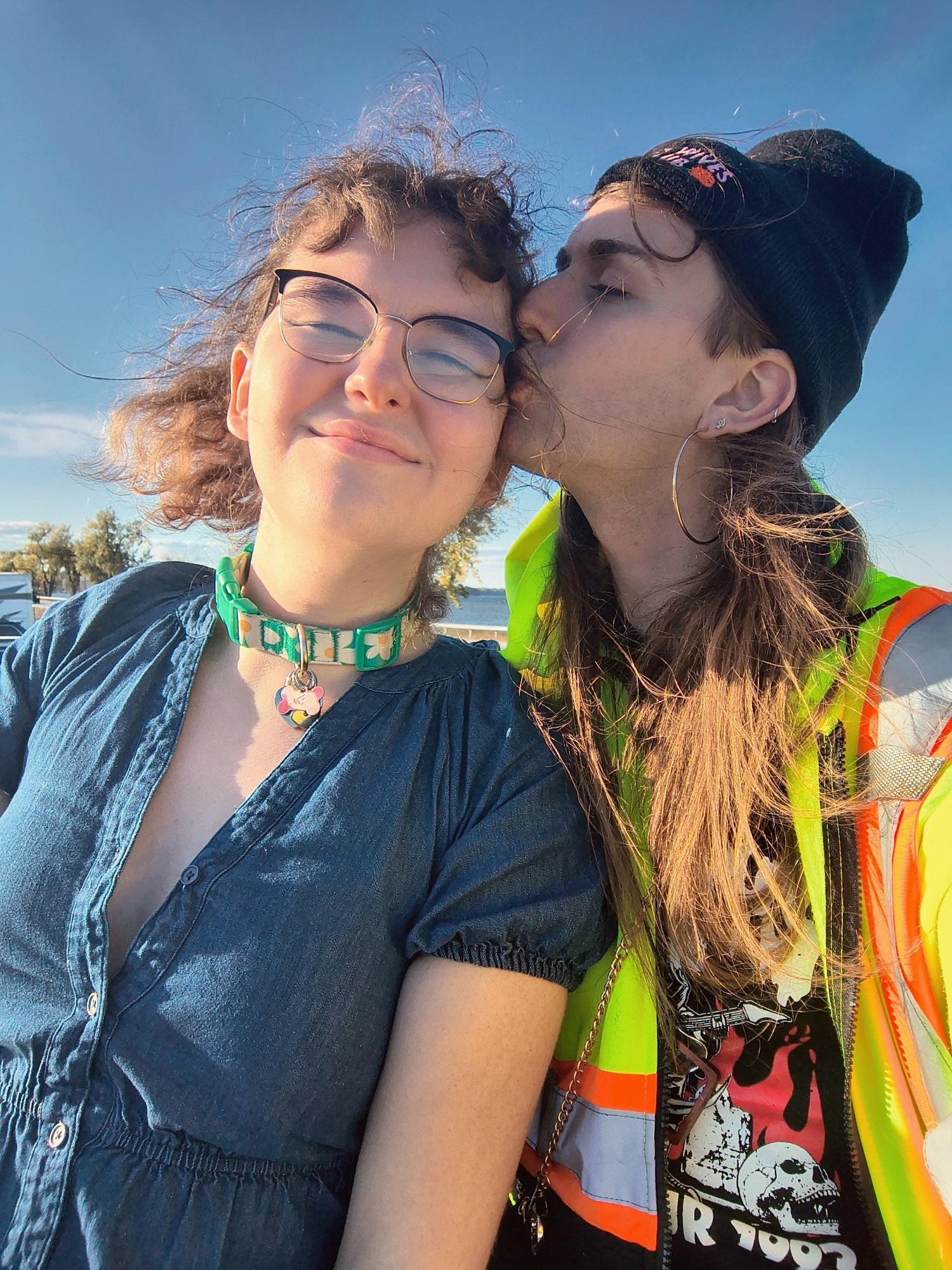 Colie kissing the cheek of her beautiful little toy. Rayna is wearing a denim dress and its collar & glasses. The sun shines brightly on its face as it smiles