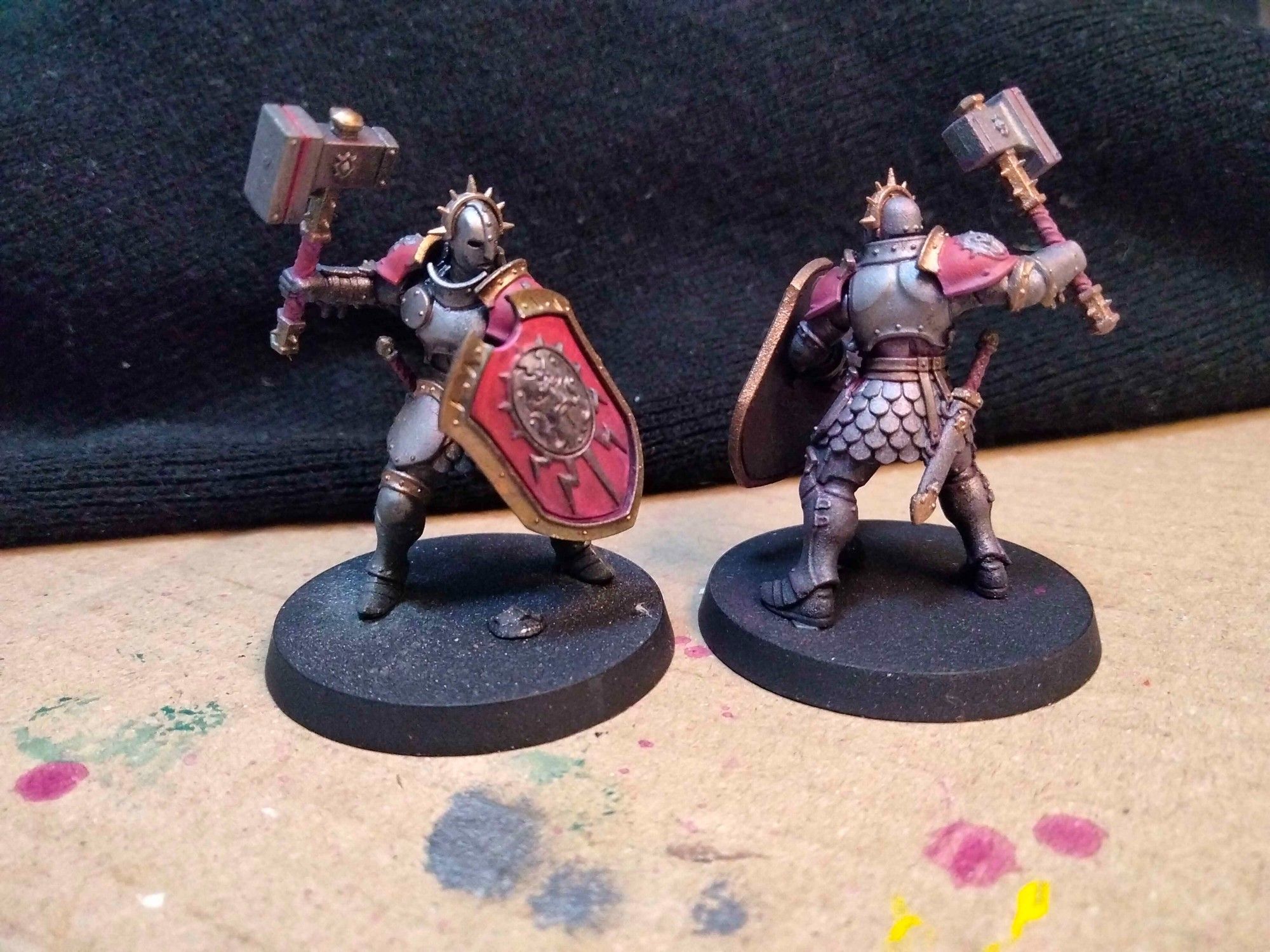 work in progress colour scheme for Stormcast Eternals. Dark iron and worn out gold, with some red-to-purple tinted shields and shoulders.