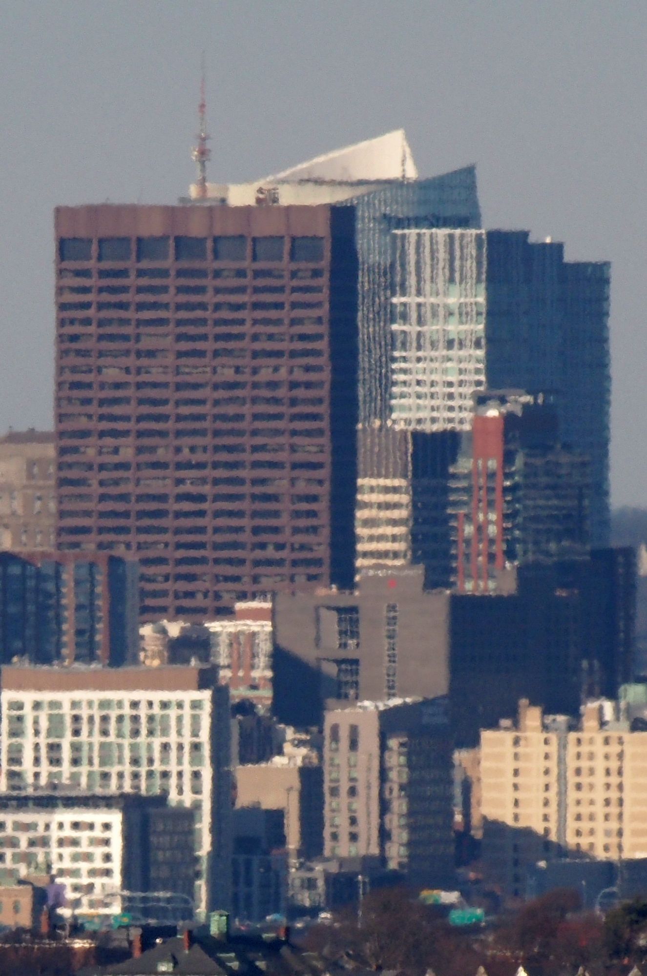 One Beacon St, One Congress and The Sudbury, photographed from Buck Hill.

The skyscraper at One Beacon St dominates the view in this photo. Behind it sits the newer Bullfinch Crossing which contains One Congress (aka State Street) and The Sudbury. 

Below Bullfinch Crossing is the John F Kennedy Federal Building and 45 Province. Several smaller buildings from Downtown Crossing and Chinatown are visible at the bottom of the frame. There are also a couple of highway signs on I-93 North that are visible. The full list of visible buildings follows. All of these are located in Boston MA.

One Beacon St, 1 Beacon St
One Congress, 1 Congress St
The Sudbury, 100 Sudbury St
John F Kennedy Federal Building, 15 Sudbury St
45 Province, 45 Province Street
Hotel AKA Boston Common, 90 Tremont St
660 Washington, 660 Washington St
7Ink Boston, 217 Albany St, 
AC Hotels Marriott, 225 Albany St
40 Traveler, 40 Traveler St
Troy Boston Apartments, 55 Traveler St
75 Kneeland St, Boston, MA 02111