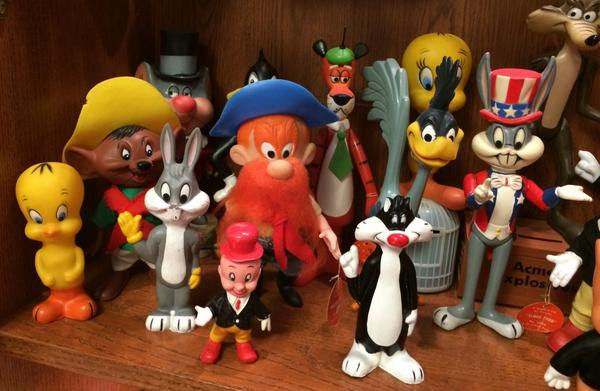 Dakin figures, all circa 1976.  The Elmer Fudd in the front is hard rubber. The Tweety, Bugs Bunny, and Sylvester in the front are squeaky toys.  Speedy Gonzales, Daffy Duck, Yosemite Sam, Cool Cat, Road Runner, and Bugs Bunny dressed as Uncle Sam are all hard plastic figures with jointed arms and legs.  Merlin the Magic Mouse is also a jointed figure but stands on a plastic base.  Wile E. Coyote is a jointed figure standing on a box of Acme Explosives and the Tweety in the back is a jointed figure standing on a bird cage.  Note that some of the original tags can be seen.