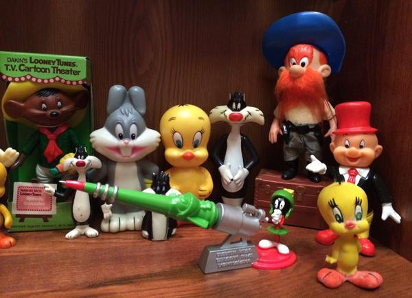 A Marvin Martian pen deskset (1998) from the Warner Bros stores containing magnets to allow the pen to rest on the lludium Q-36 Explosive Space Modulator and a Tweety squeaky toy.  Behind these items are Dakin figures, all circa 1976.  I'll not mention those already covered by the previous photo.  The chubby Bugs Bunny and Tweety are coin banks. The small Sylvester directly in front of the coin banks is a finger puppet. Sylvester and Elmer Fudd are hard plastic figures with jointed arms and legs but are smaller than the ones in a previous photo (and Elmer does not have cloth clothing).  Yosemite Sam is also a jointed figure similar to the one in a previous photo but stands on a trunk.