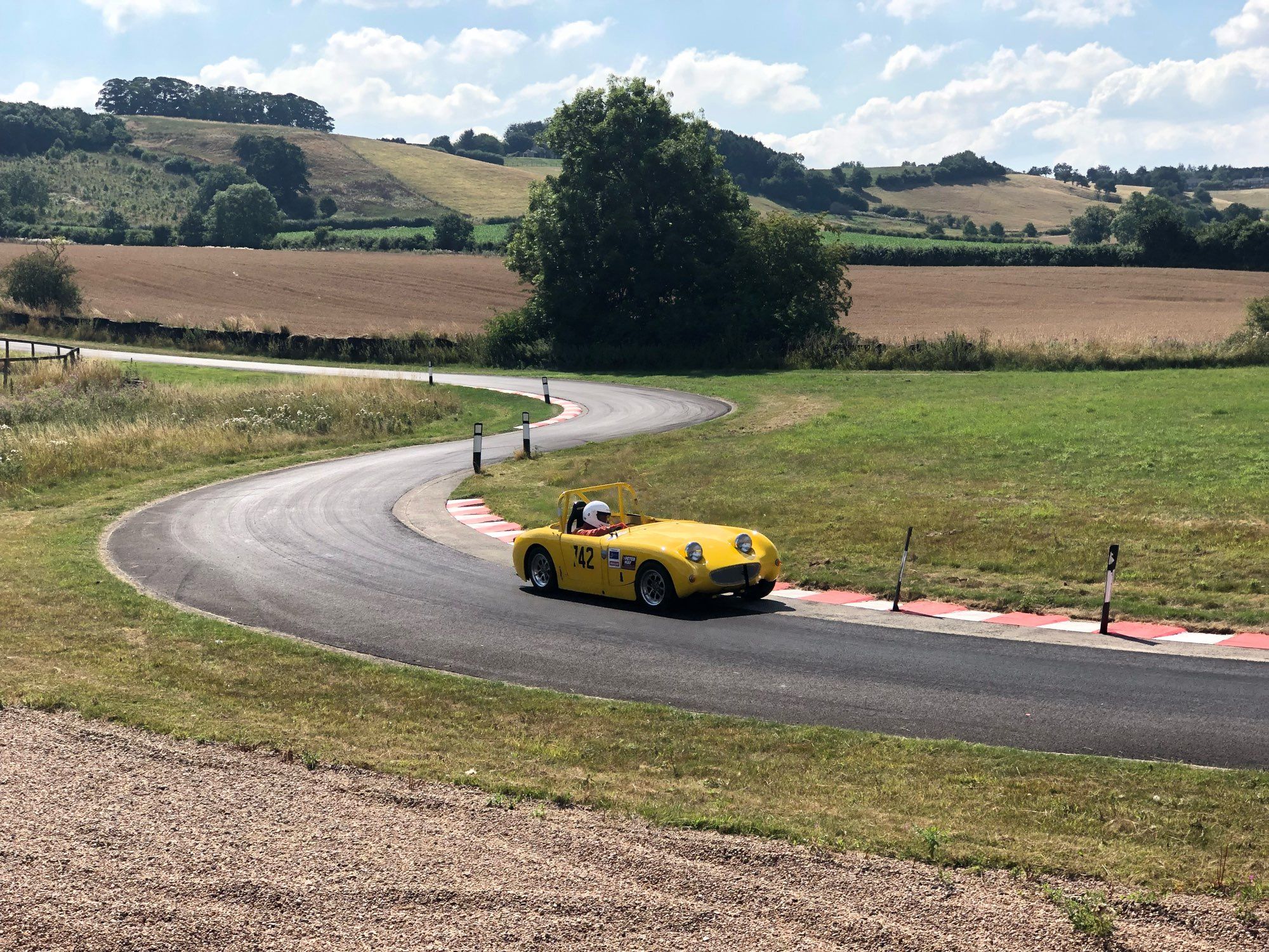 A yellow Austin-Healey ‘Frogeye’ Sprite heading down the hill at the Harewood Hillclimb, Yorkshire in August 2018.