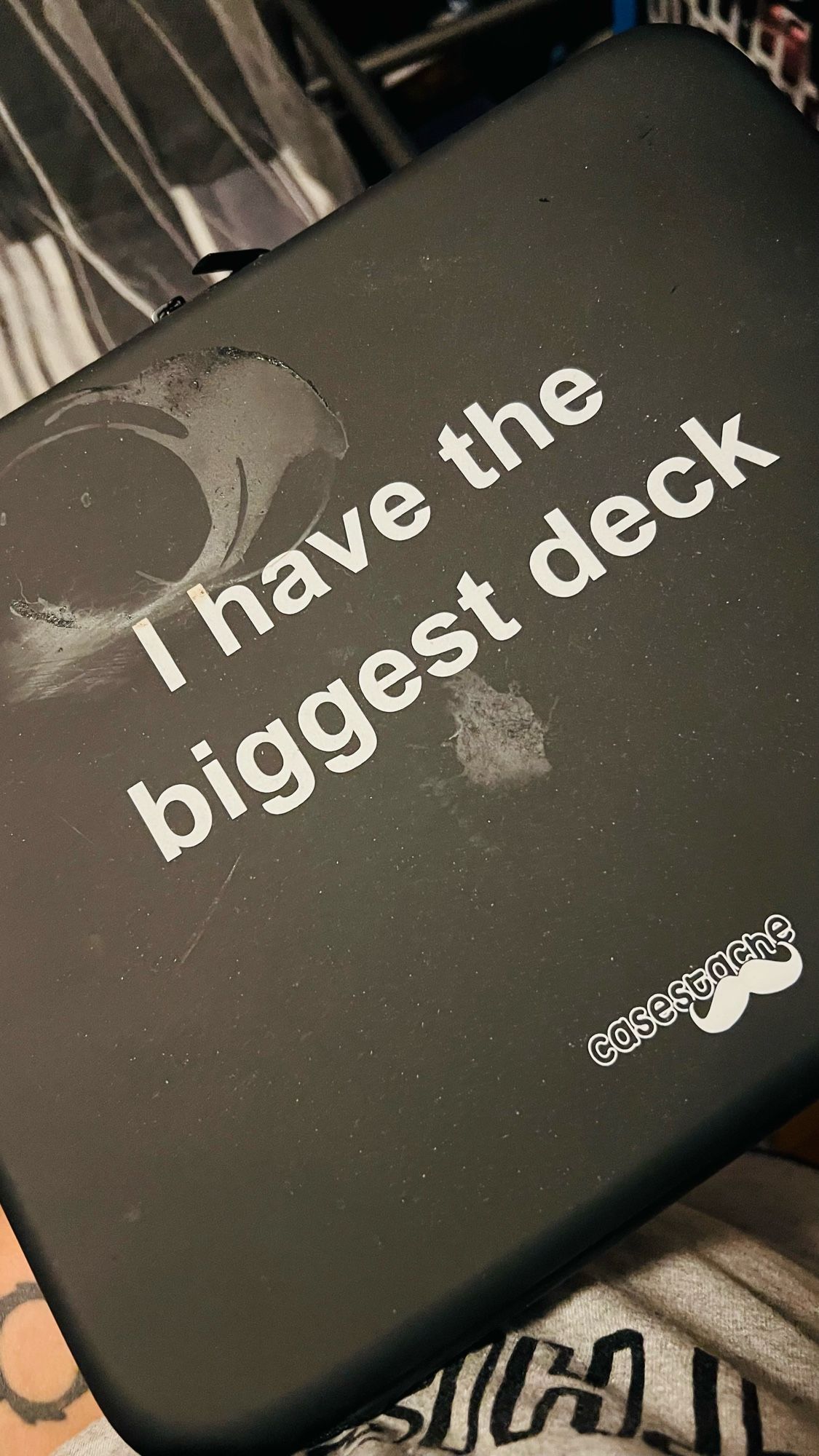 Cards Against Humanity in a black briefcase that says “i have the biggest deck”