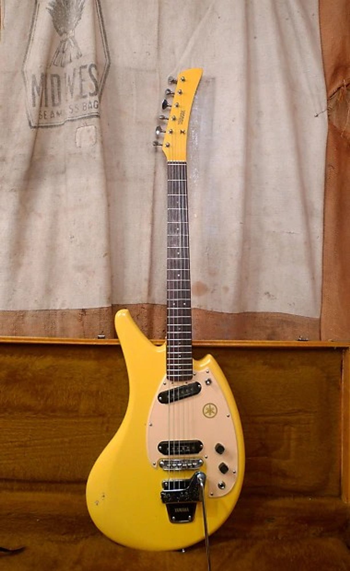 The Yamaha SG-2C Flying Banana looks like it sounds: a curvy body painted bright yellow. It's got two single coil pickups (unusually, the neck one is angled instead of the bridge one) one volume and one tone control, a 3-way switch, and a Bigsby-style trem.