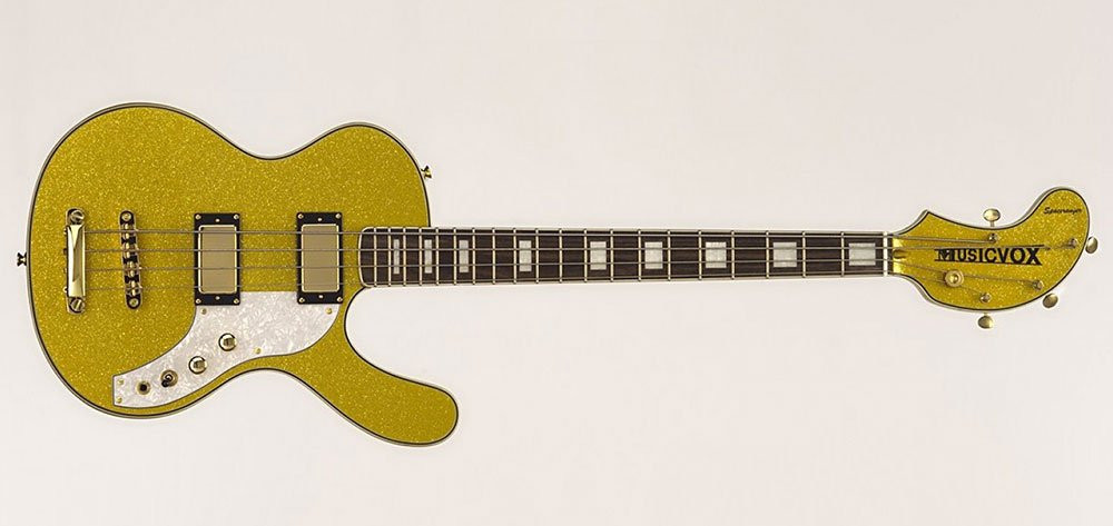 The Musicvox Spaceranger bass is kinda shaped like a Les Paul, but with the lower horn of the body extended waaaay out and with a 1/3 split headstocks that's curved like a banana. This one is gold with a white pickguard and block inlays on the neck.