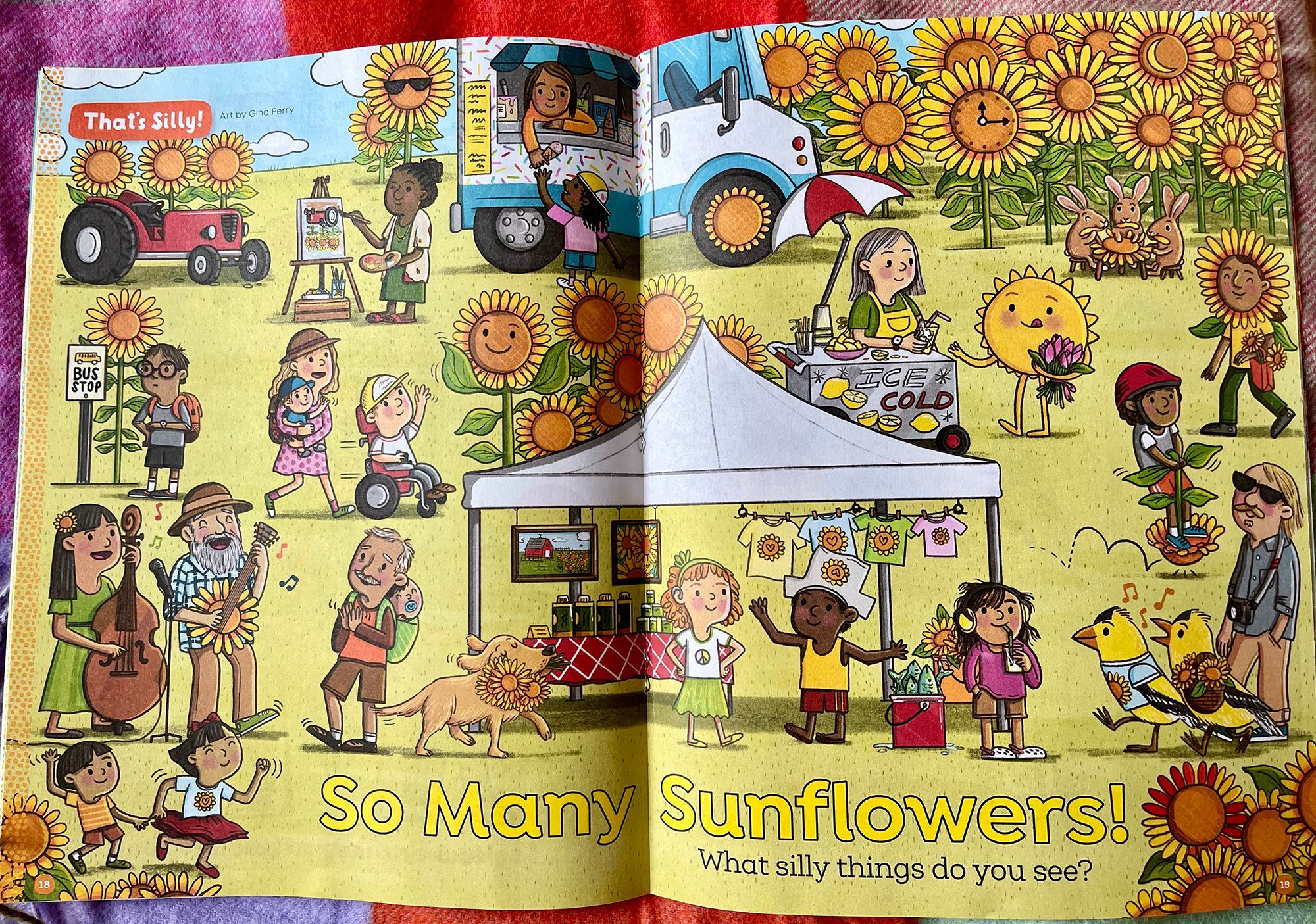 Photo of a magazine spread, High Five magazine's That's Silly feature. Titled 'So Many Sunflowers!' we see a fall festival with many sunflowers, a tent, large goldfinches, musicians, an ice cream truck and more. Art by Gina Perry