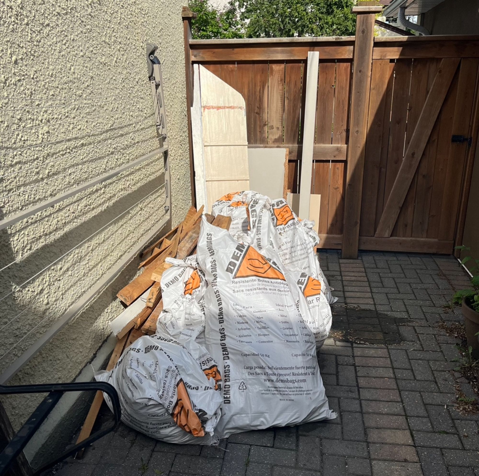 Big ol’ pile of debris on the patio in the backyard. There’s a stack of nasty wood, bristling with nails, and 7 or 8 large, white, and very heavy (trust me!) demolition bags full of yuck.