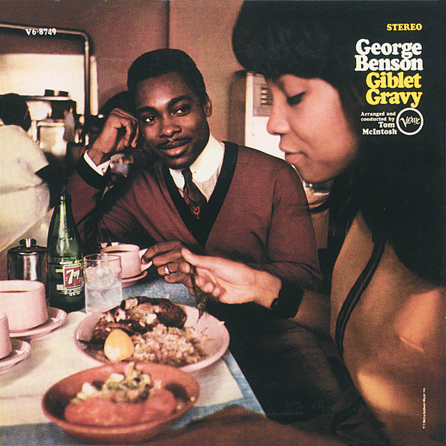 Album cover for Giblet Gravy by George Benson. The image shows a young Black man in a red cardigan and tie sitting at a diner counter, resting his chin on his hand and looking toward the camera with a relaxed smile. In the foreground, a woman in profile is eating a meal, while plates of food, pink mugs, and a green glass bottle of 7 Up are visible on the counter. The album title and credits are printed in the upper right corner.