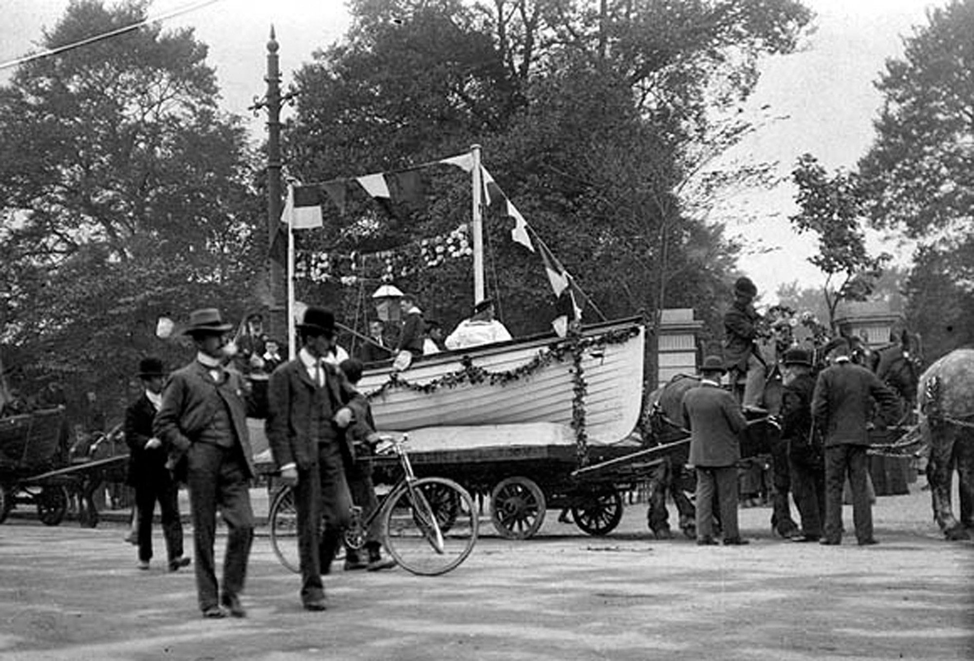 Boat decorated with garlands as part of an annual fund-raising flag day held by the Royal National Lifeboat Institution at St Stephen's Green. c1897-1904. The National Library of Ireland. No known copyright restrictions.