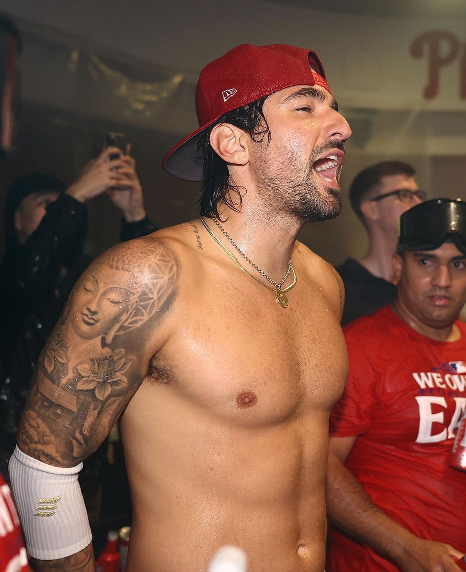 Nick Castellanos shouting something during the Phillies Clubhouse celebration for winning the National League East. He is shirtless and drenched in beer.