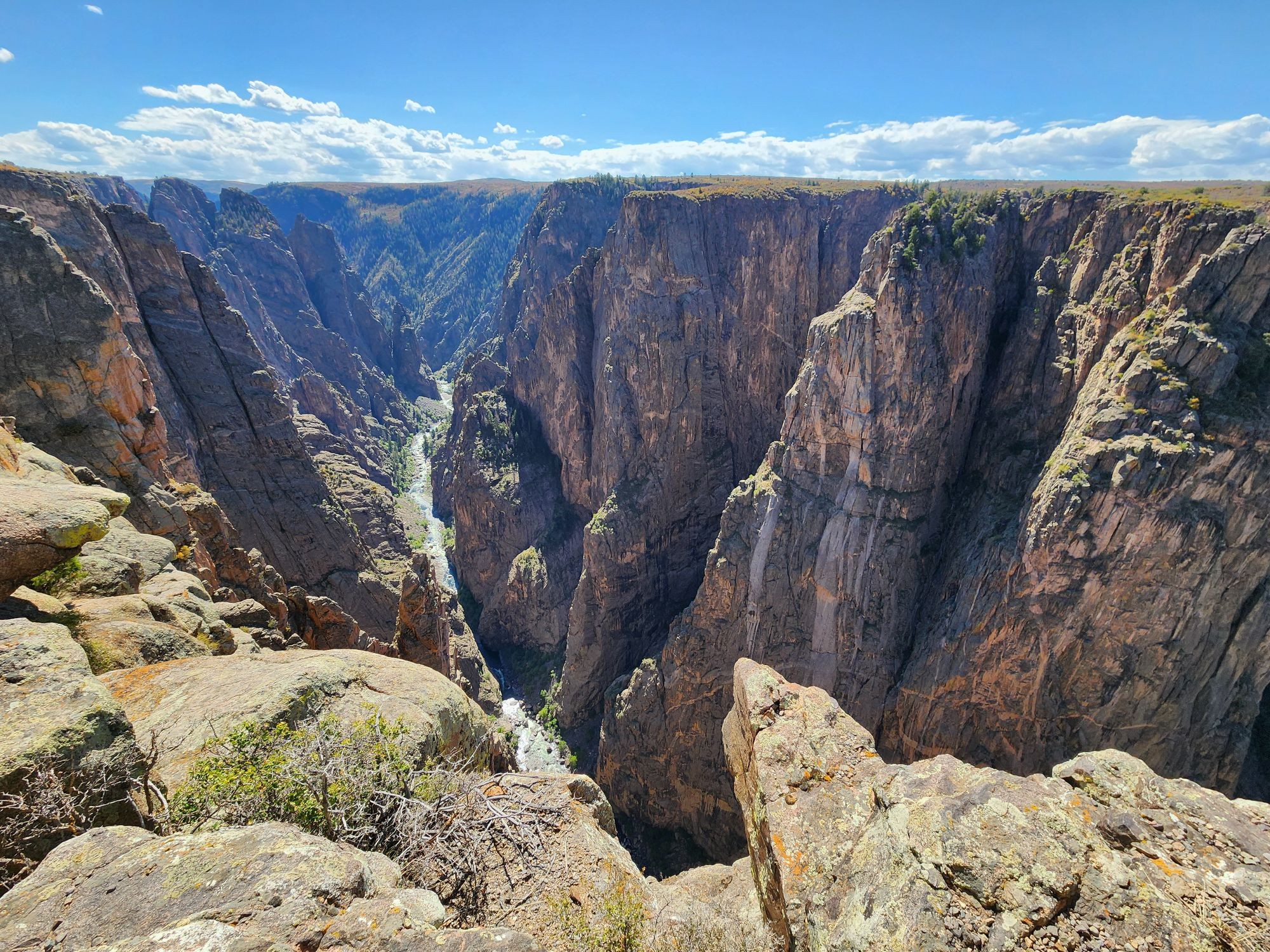 A view of a deep black rock lined canyon.