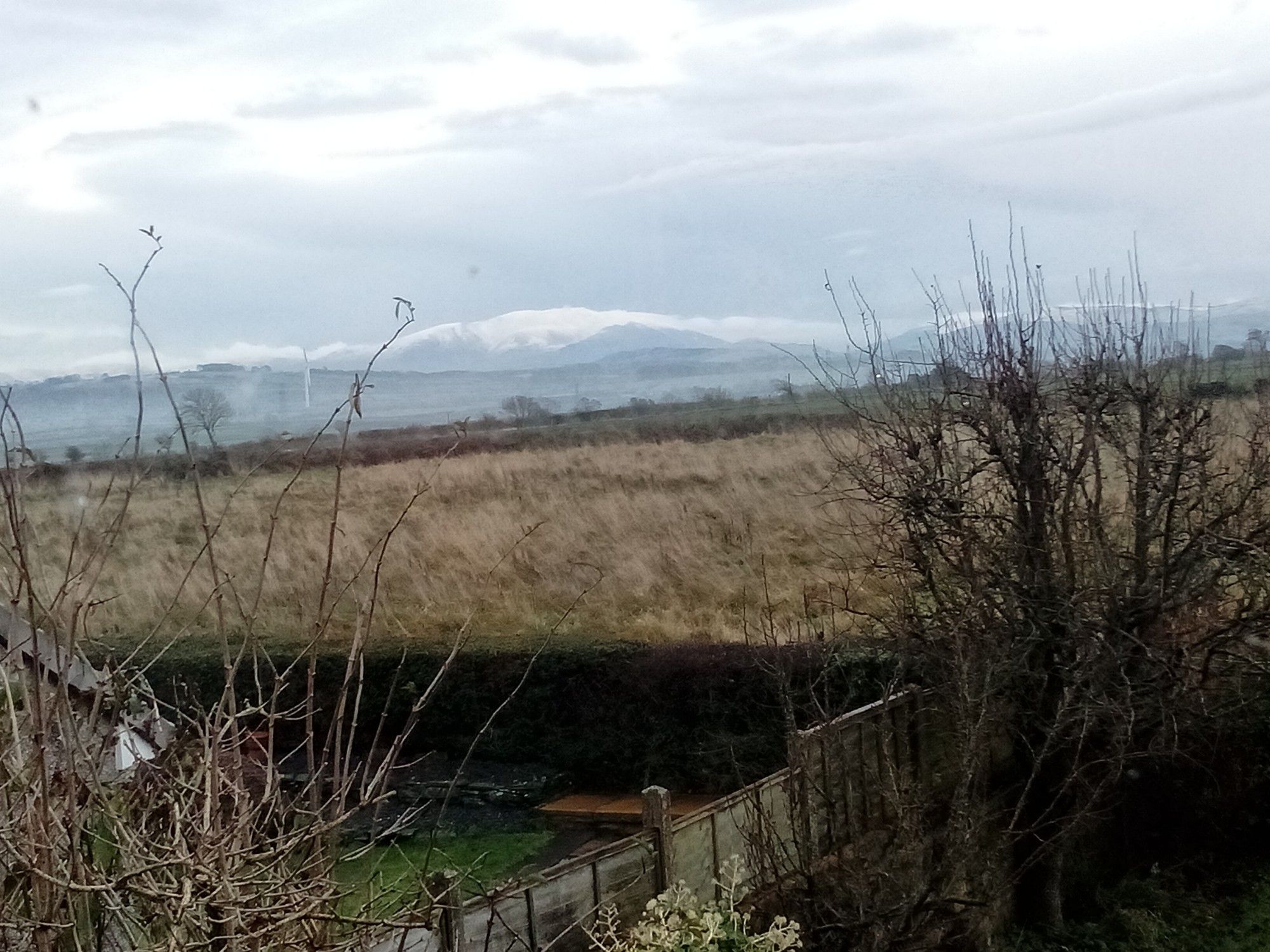 Foreground: scruffy garden
Mid ground: rough pasture
Distance: snow. topped fells