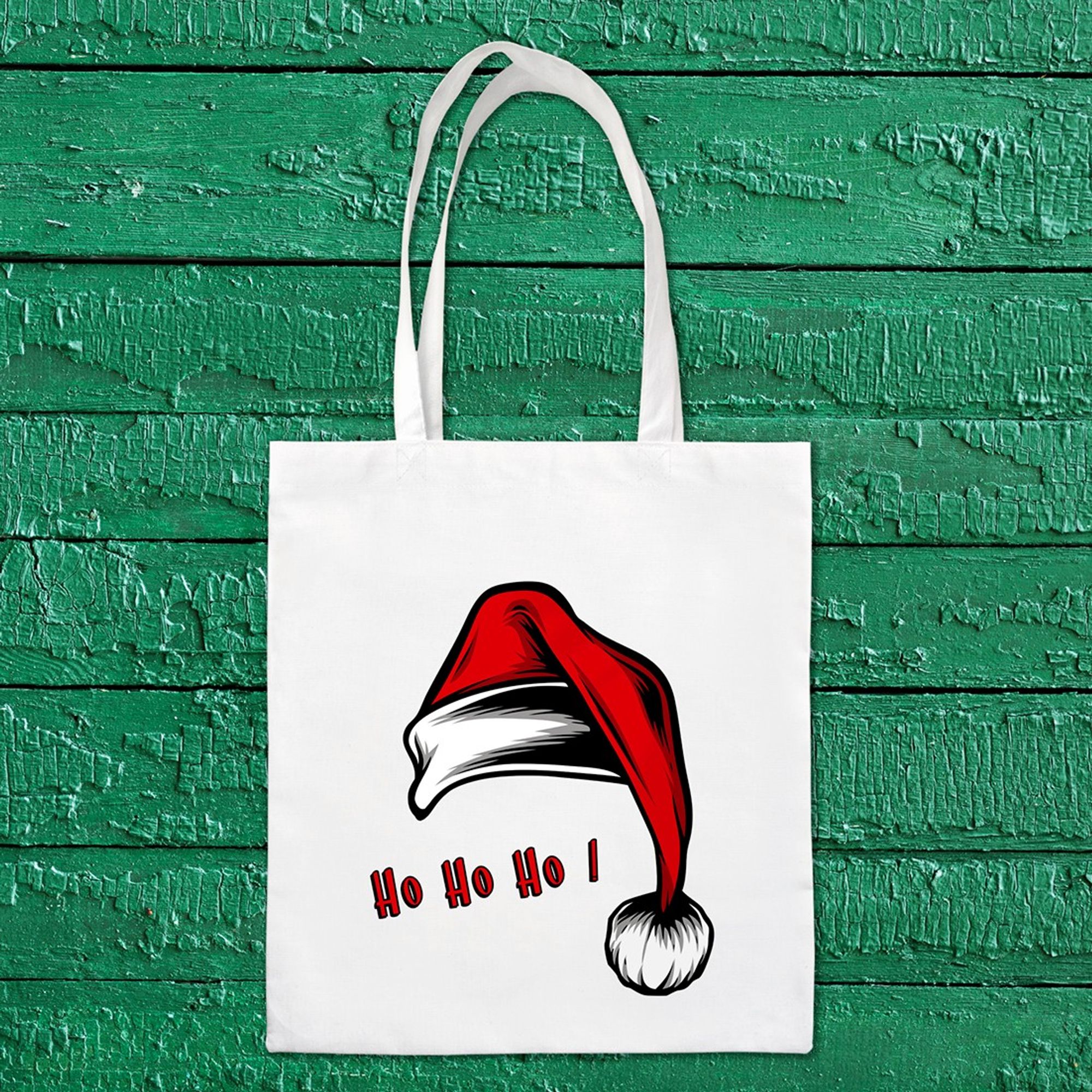 Tote bag de Noël blanc ayant pour motif un gros bonnet de Noël rouge et son pompon et le texte "Ho ho ho"