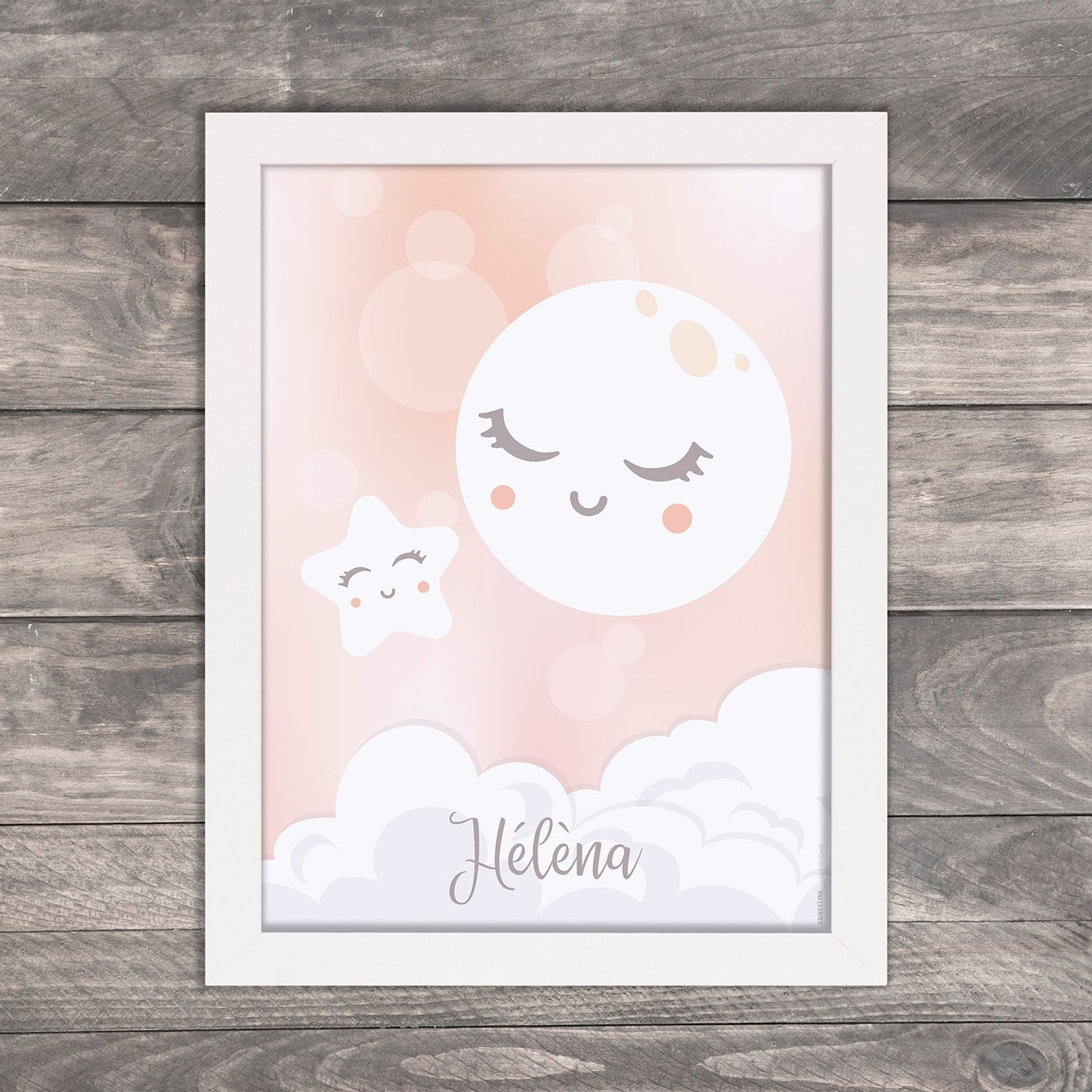 Affiche personnalisée avec prénom pour chambre d'enfant ou cadeau de naissance représentant une lune ronde et une étoile toute deux souriantes sur fond rose pastel, présentée avec l'option cadre blanc.