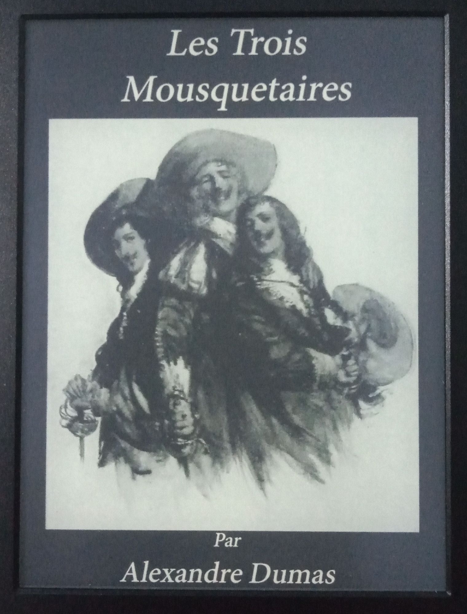 Couverture du livre Les Trois Mousquetaires, par Alexandre Dumas, édition de Project Gutenberg, en niveau de gris, dans un écran de Kindle.