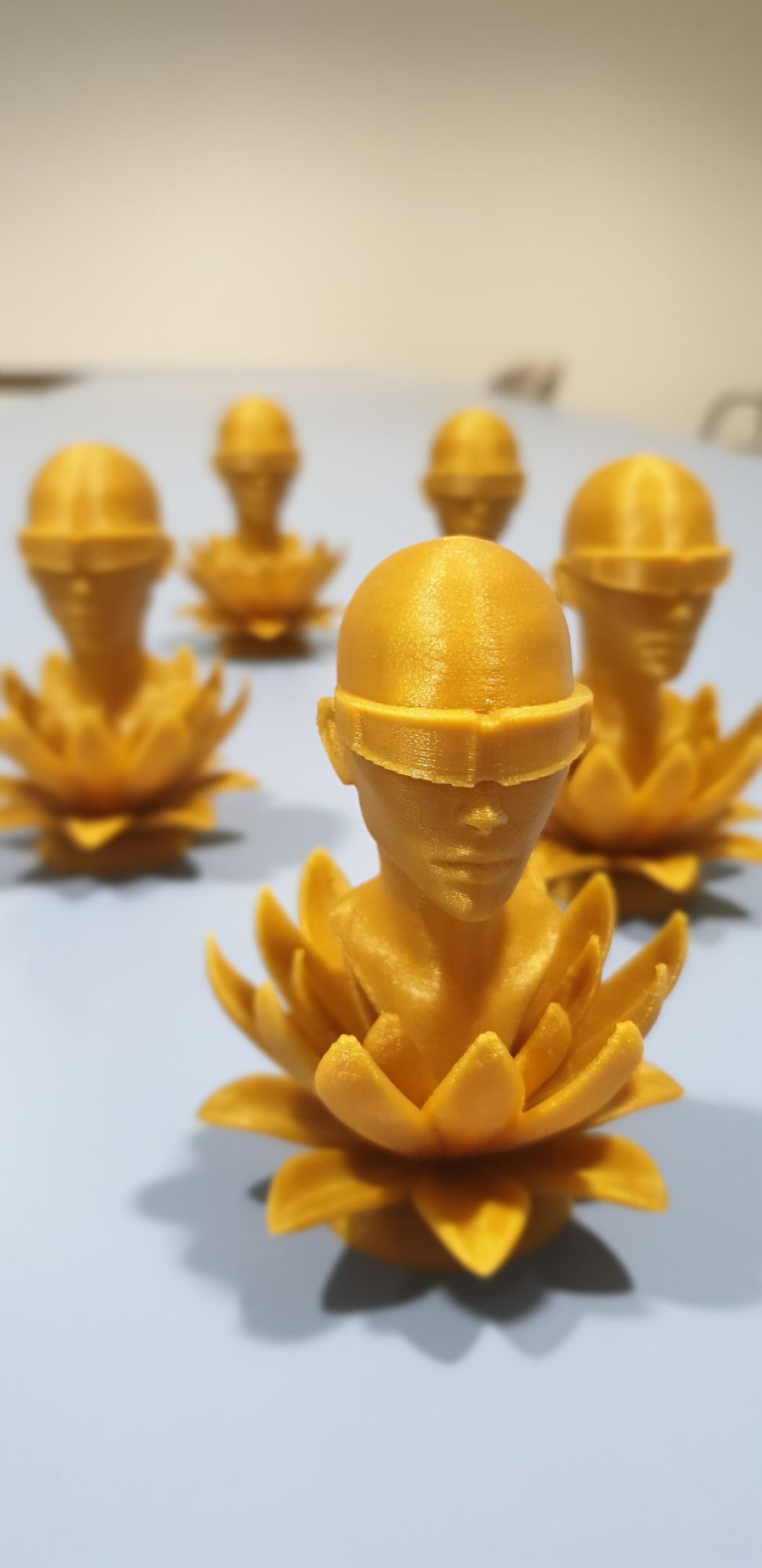 mehrere kleine goldene Figuren. Ein Kopf mit VR Brille, der aus einer Lotosblüte erwächst