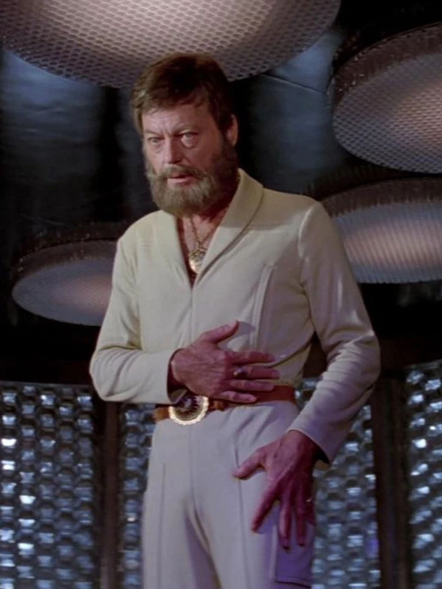 Bones McCoy in a white leisure suit that opens deep into the chest, allowing us to see that he’s wearing a medallion. The suit also has a big gold belt buckle. Bones, meanwhile, has a big beard.