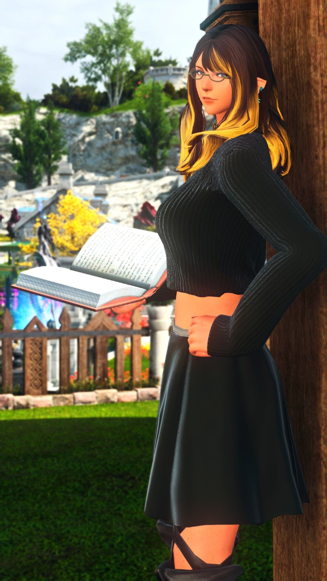 Annie stands on her front porch, an open book in her hand as she looks over shoulder towards the viewer. She's wearing a cropped black sweater and a black nearly-knee length skirt.