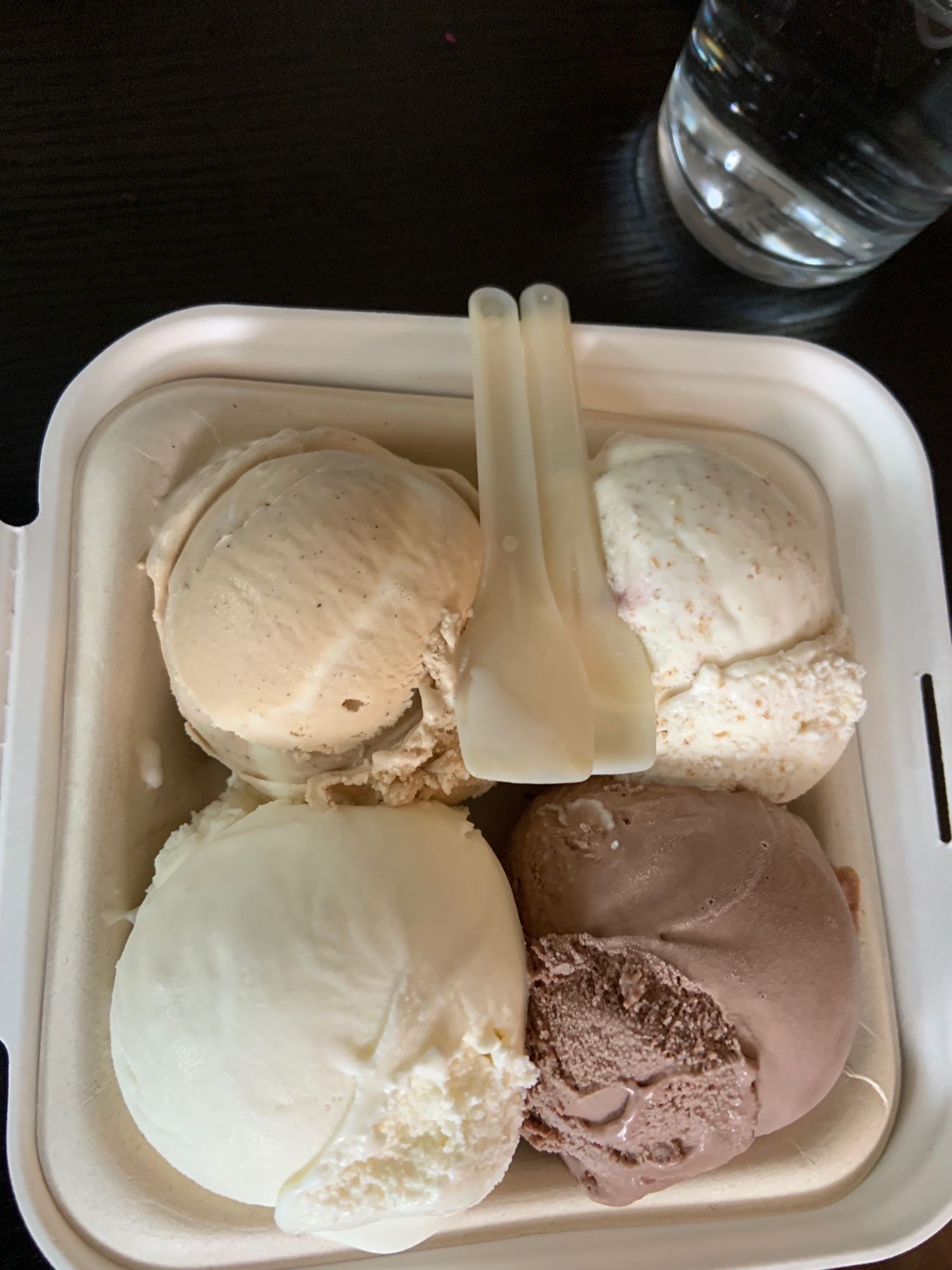 Photo of 3 scoops of ice cream with two plastic spoons, in a plastic container