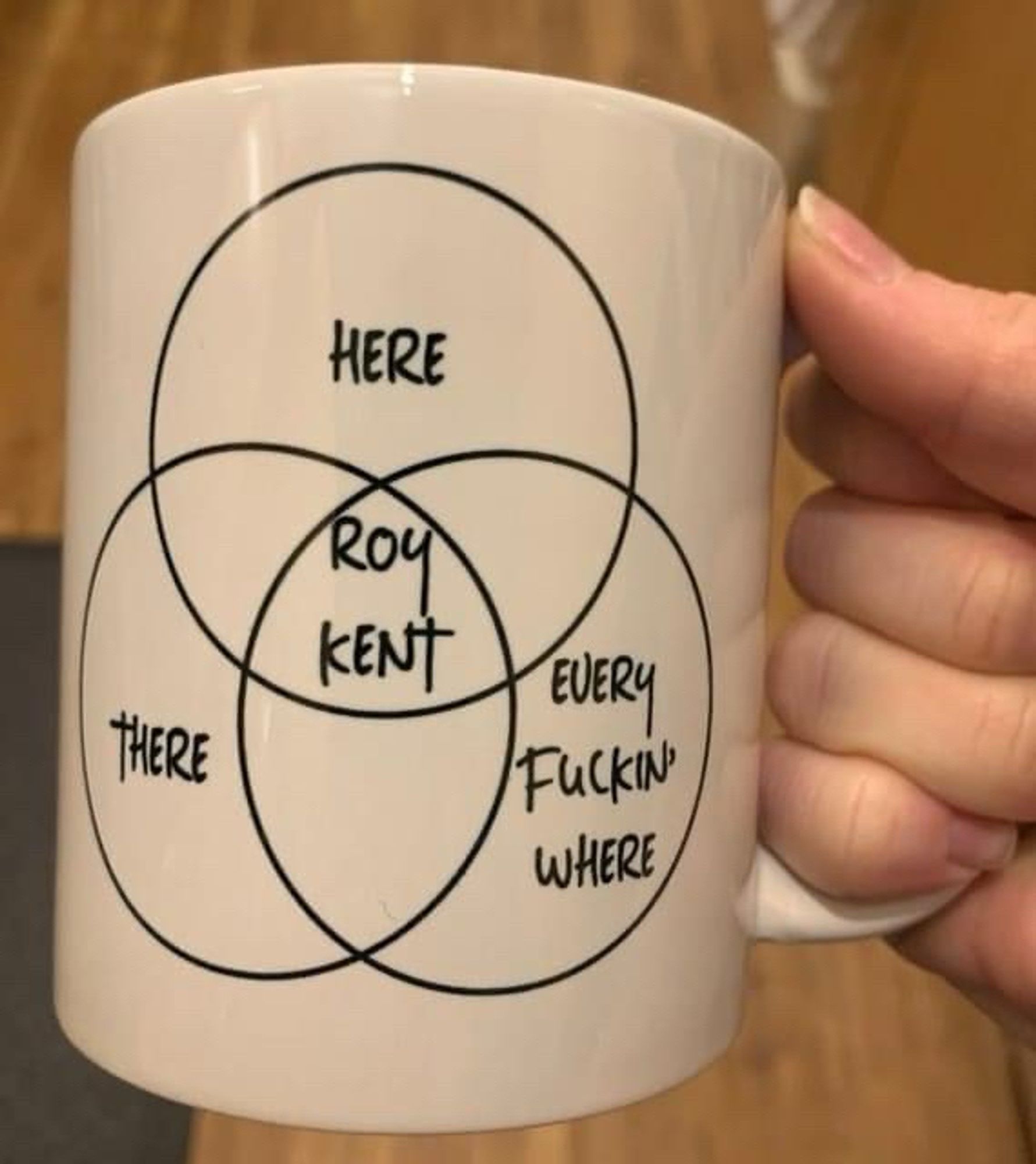 Venn diagram in black on a large white coffee mug with Here, There, Every Fucking Where in the outer circles, and Roy Kent in the middle where they all intersect.