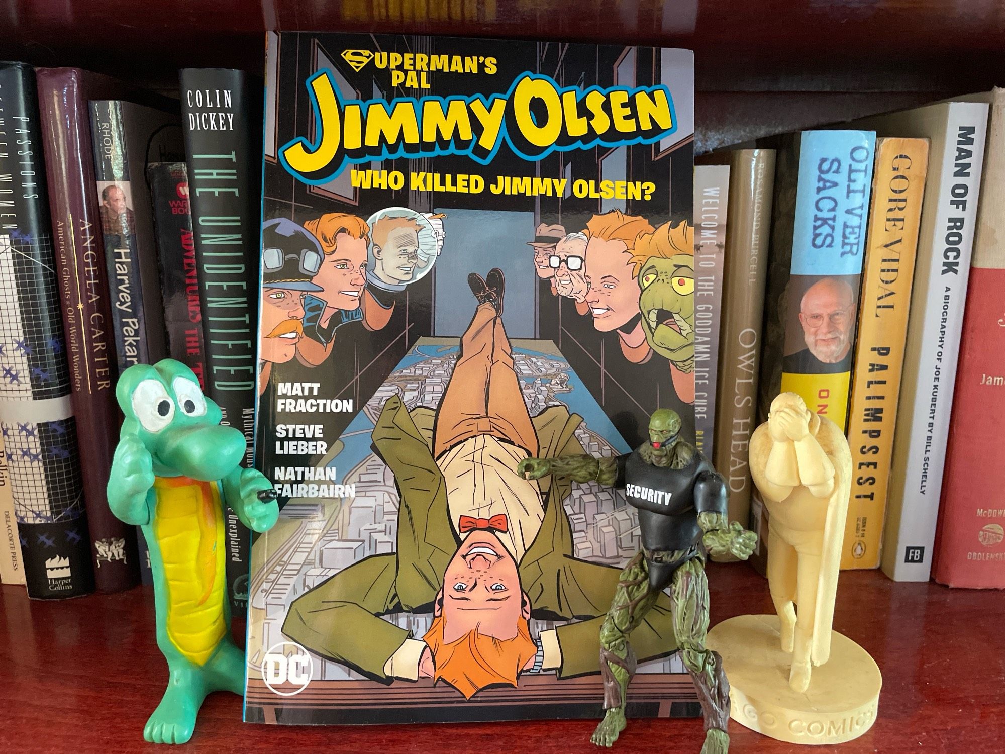 The Superman’s Pal Jimmy Olsen graphic novel, surrounded by plastic effigies of other comics characters