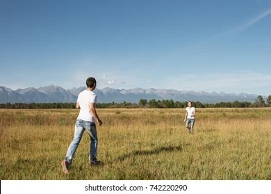 Two people running towards eachother in a field