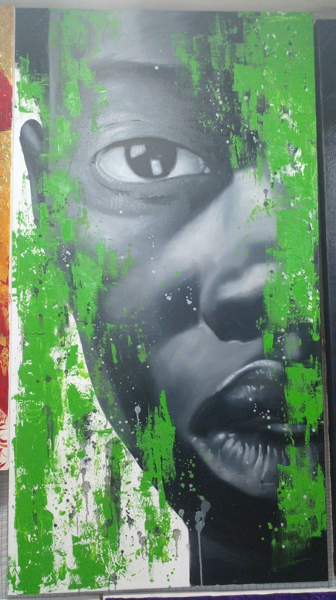 a painting of a face, looking at the viewer, green paint coming down in messy strips vertically over and around his face, a white background 