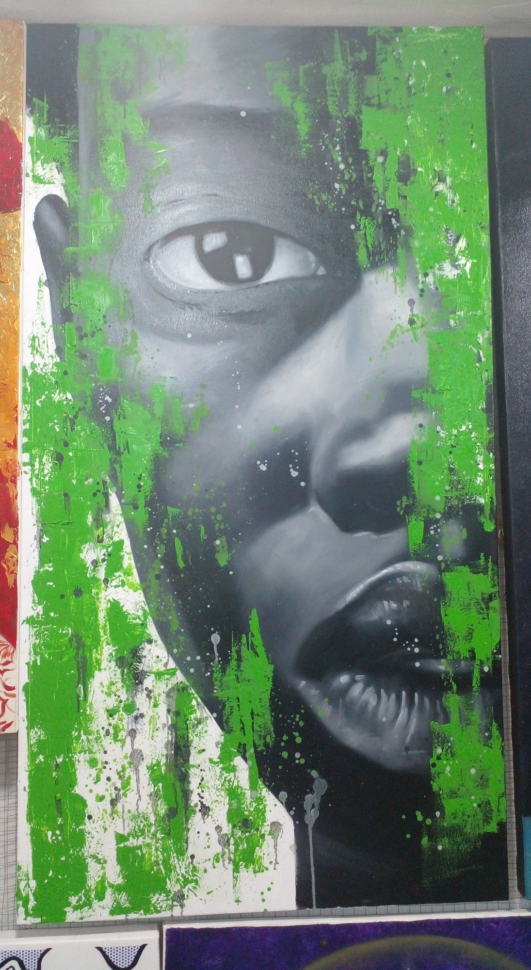 a painting of a face, it is a tall narrow shaped canvas, half the face is shown, there is bright green paint passing through in vertical strips