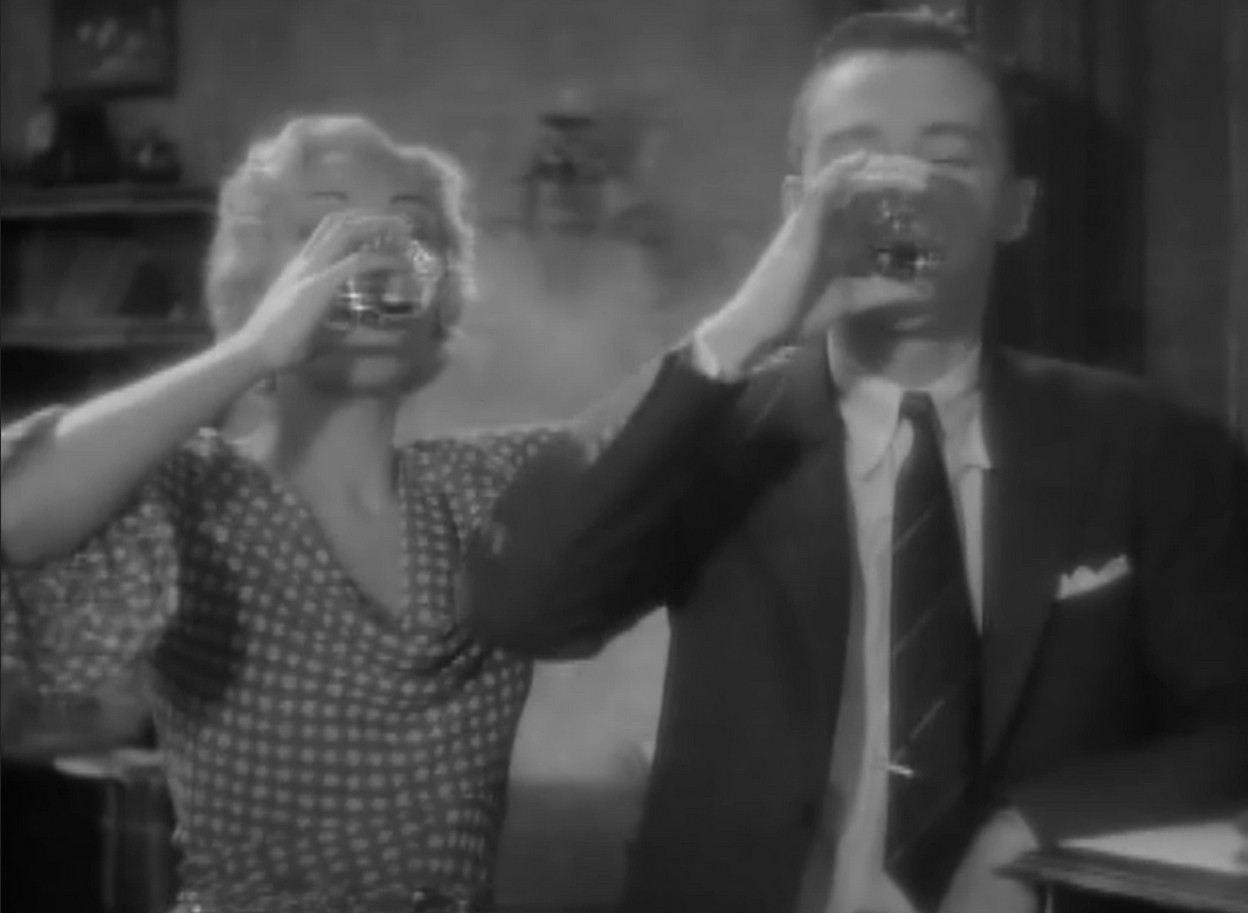 an image from the movie of two figures, the female lead with blonde hair and a male characters, drinking alcohol from shot glasses, facing the viewer